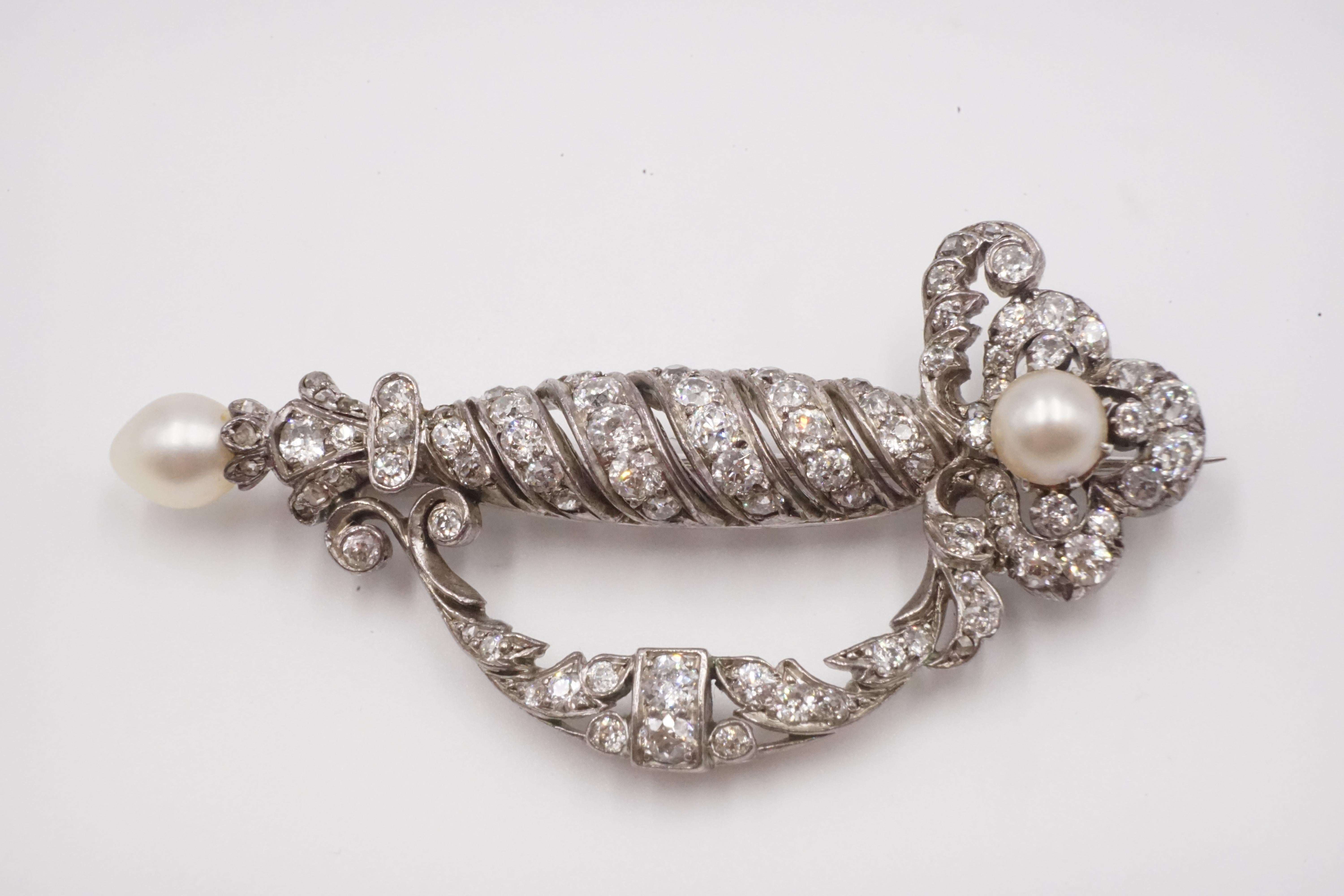 A ceremonial sword shaped Edwardian natural pearl, diamond and platinum brooch the tip and the grip of the sword have 2 natural pearls the diamonds are rose and old cut diamonds.

Measures W:6.2cm H:3.1cm D:1.2cm

Weight: 14.1g