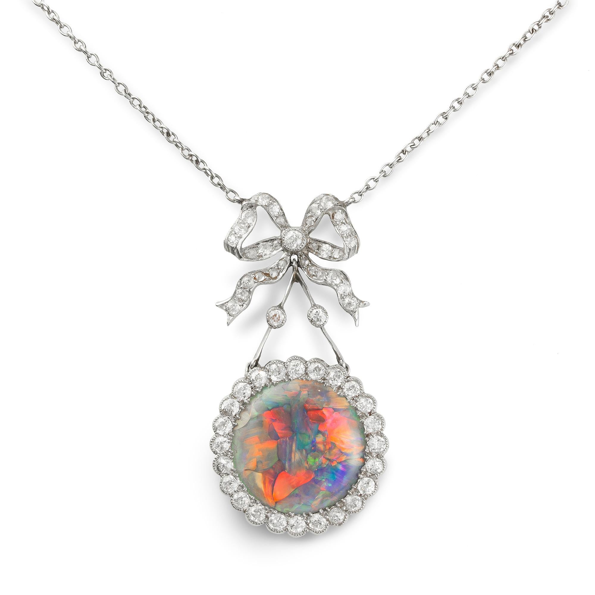 Pendente edoardiano con opale e diamanti; l'opale circolare centrale è circondata da diamanti taglio brillante in un'incastonatura millegradi in platino, sospesa da un fiocco di diamanti fissato a una catena in oro bianco, circa 1910; il pendente