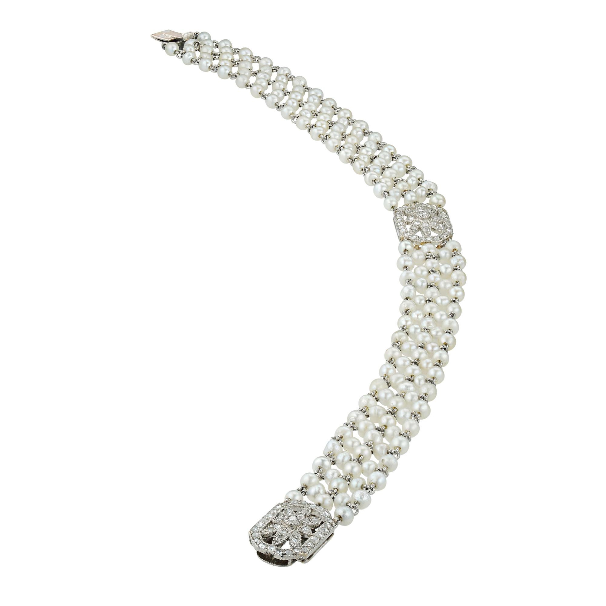 An Edwardian pearl and diamond bracelet, consisted of two openwork diamond encrusted plaques, linked with pearl-set mesh, all mounted in platinum, circa 1905,total length approximately 20cm, gross weight 13.6 grams.

Edwardian bracelet in good