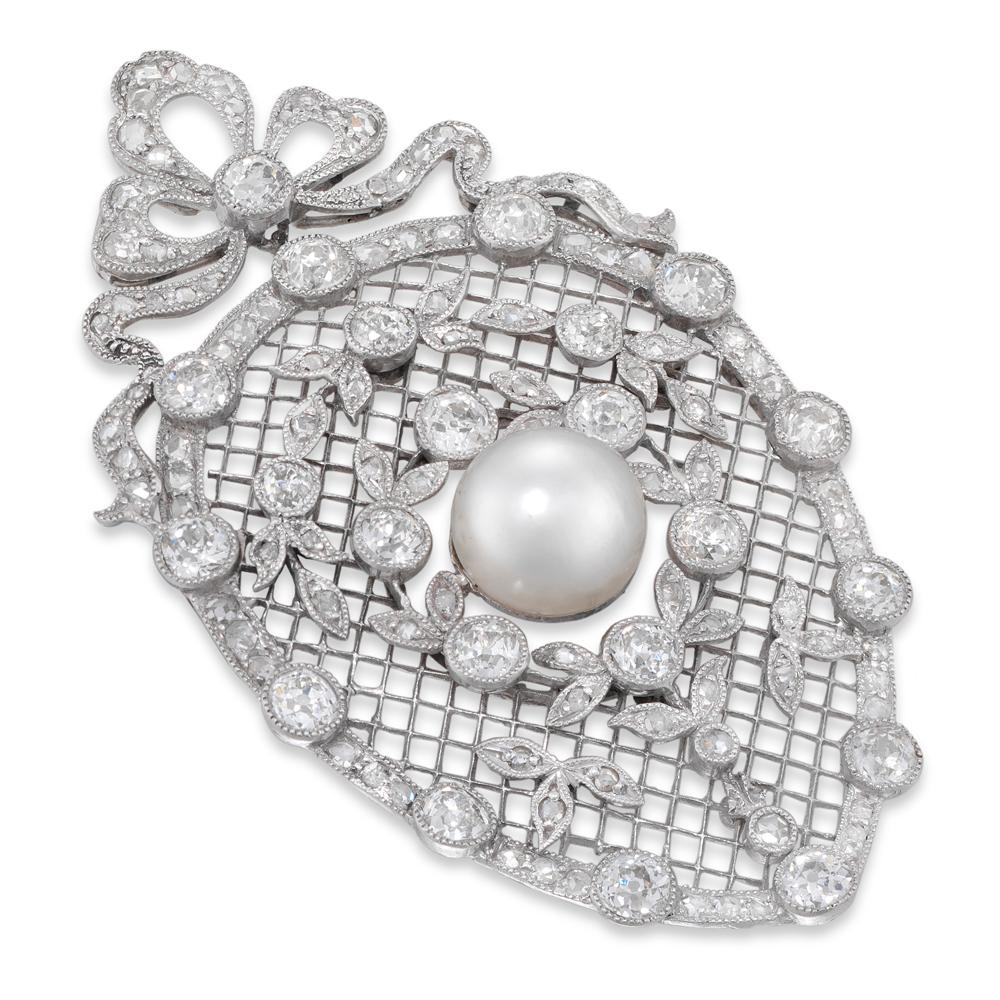 An Edwardian oval diamond lattice brooch with a certificate central natural pearl weighing 4.23 carats, surrounded by two diamond laurel details, set in a platinum lattice all within a diamond border and surmounted by a diamond set bow, the