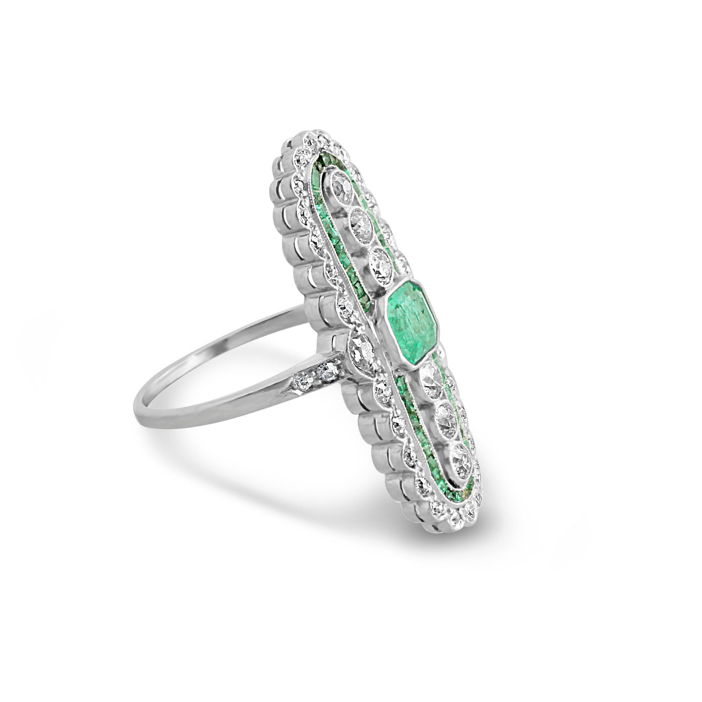 An Edwardian emerald and diamond tablet ring. A gorgeous openwork design set at the centre with an octagonal-cut emerald surrounded by approximately 0.65 carats of diamonds mounted in platinum. The diamonds are of good colour and clarity H-I, VS.