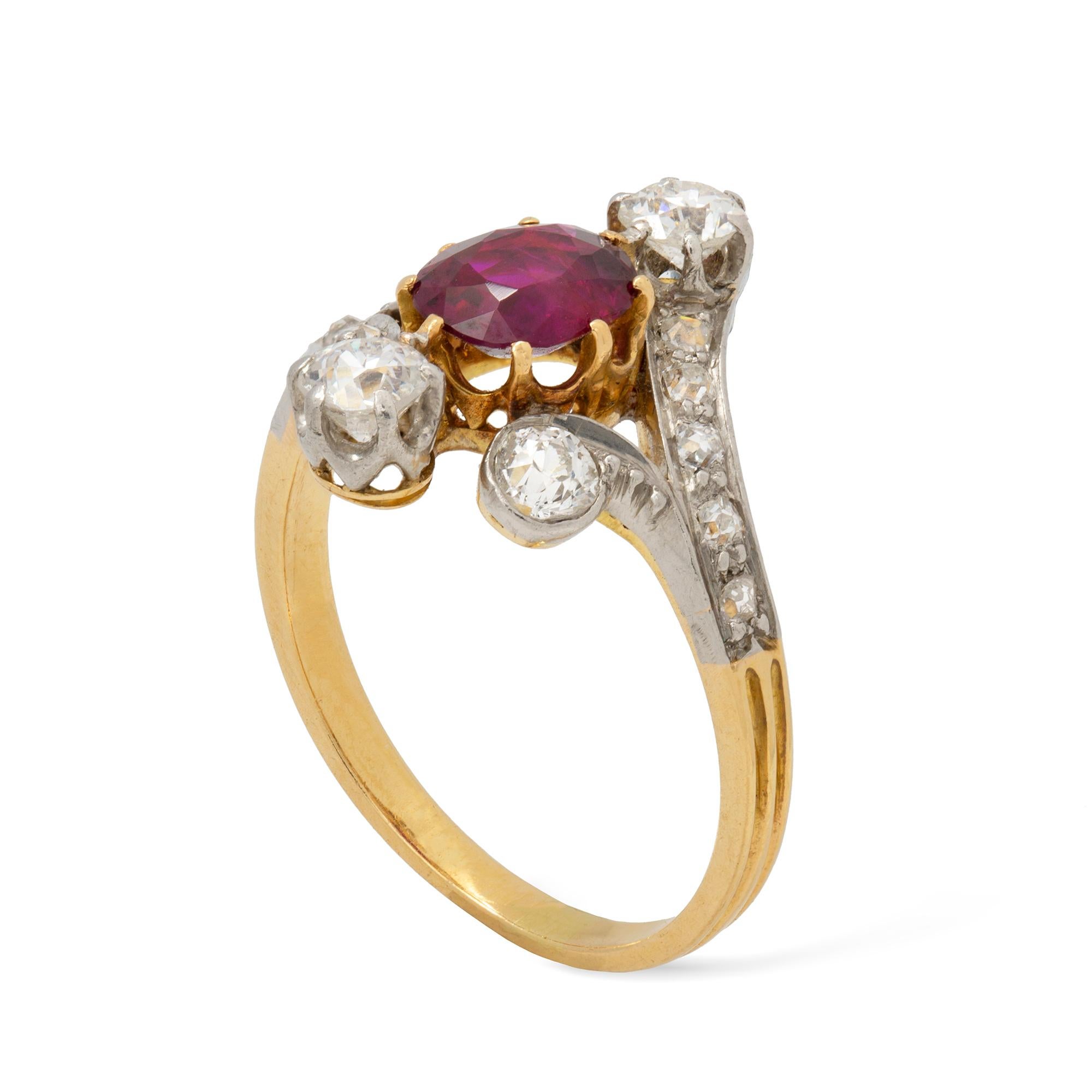 An Edwardian ruby and diamond ring, the oval faceted ruby weighing 0.94 carats claw-set between old-cut diamond-set scroll designed split-shoulders, the diamonds estimated to weight 0.8 carats in total, all set in platinum  and yellow gold, to gold