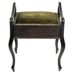 An Edwardian stained Beech piano stool with period green fabric printed 