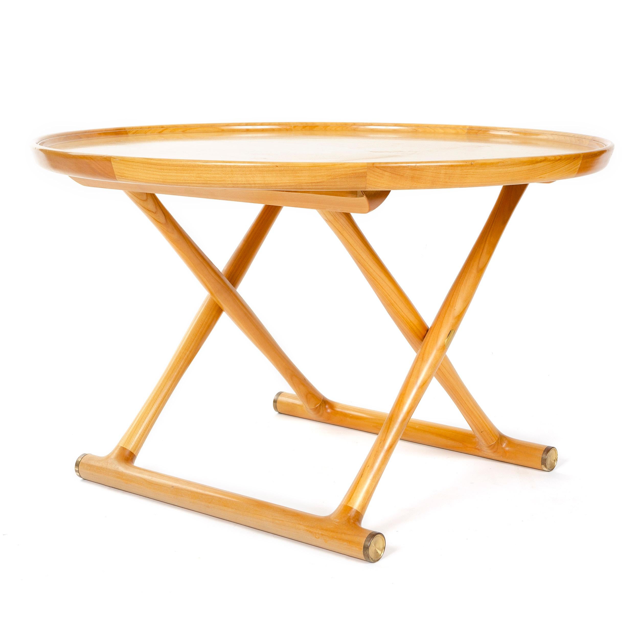 An Egyptian table designed by Mogens Lassen in light maple wood with a circular top, folding X-form legs and brass capped floor stretchers. Crafted by cabinetmaker A. J. Iversen in Denmark circa 1950s.
  
