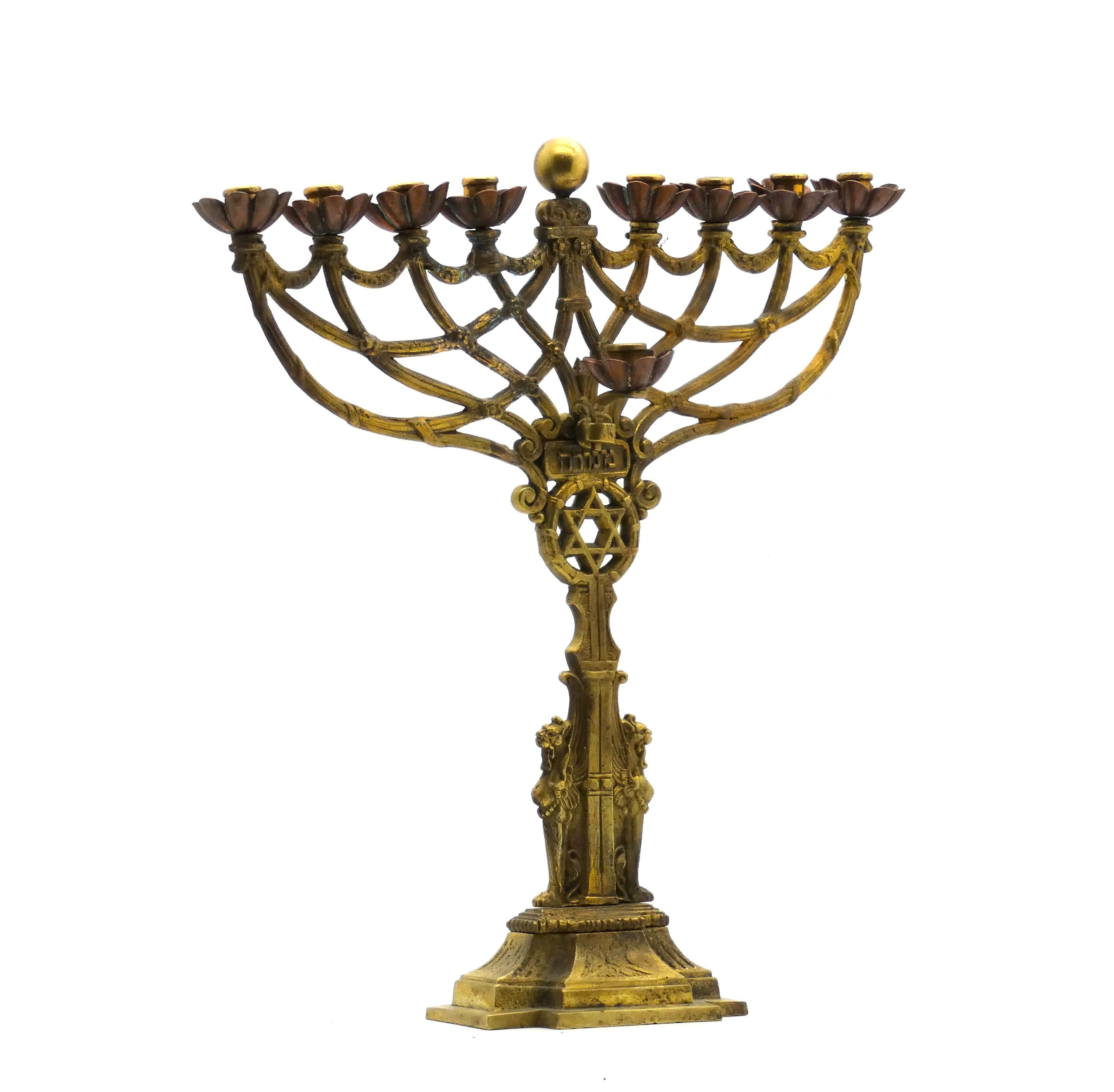 Egyptian-revival Hanukkah Lamp made in Germany in the late 19th century.

Expertly cast brass and copper featuring highly detailed motifs such as a Star of David in a vine wreath surmounted on an Egyptian column stem flanked by two upright griffins