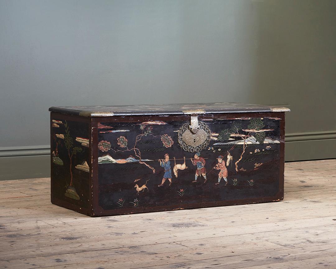 Constructed from beautifully incised coromandel panels, depicting the fruits of a successful hunting trip, amidst mountainous landscape, with blossoming flowers, draping boughs of foliage, and further figurative scenes. With large pierced and