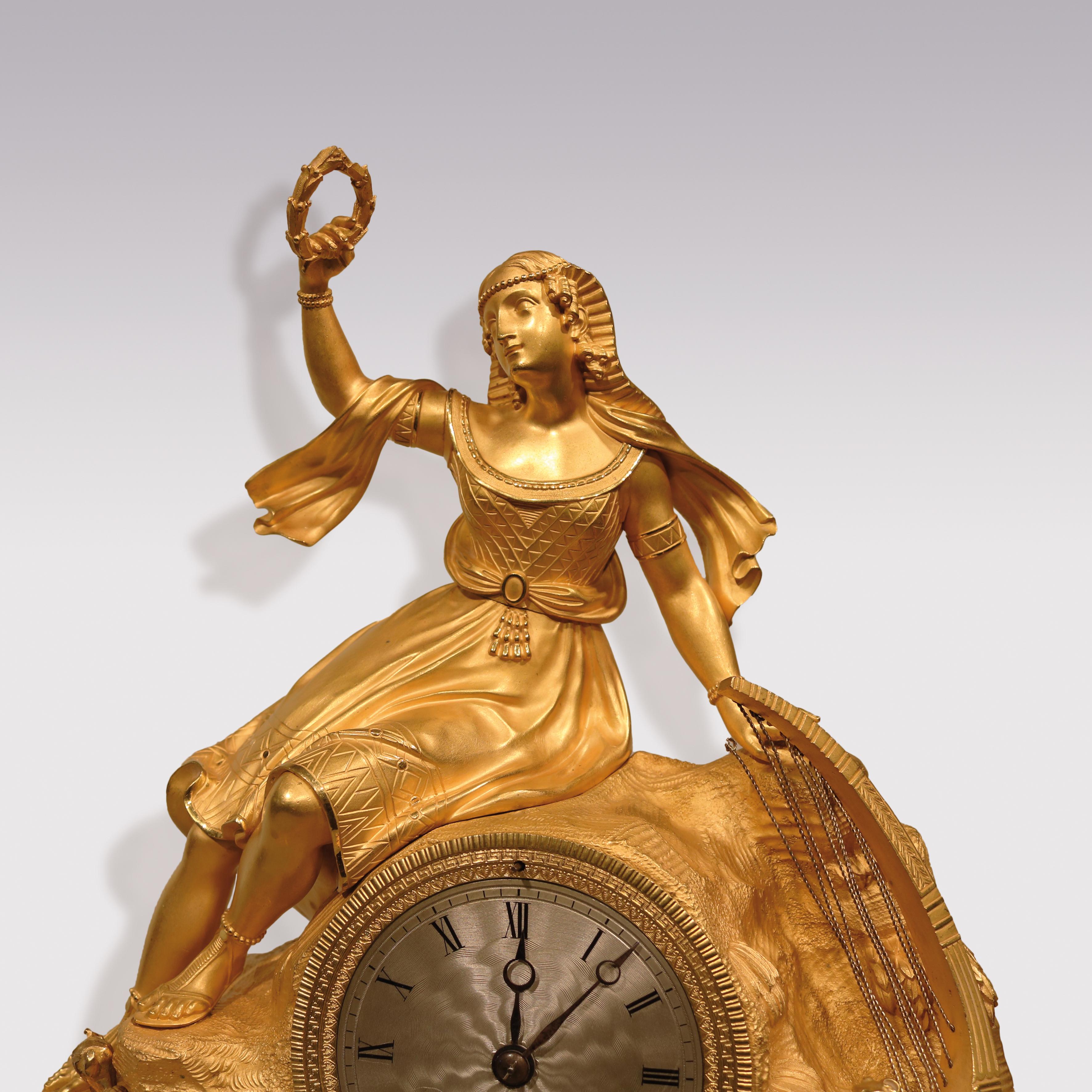 An impressive early 19th century French clock by T H re Le Roy, having 8 day striking silk-suspension movement with silver dial. The clock, mounted in ormolu case depicting Egyptian lady with lyre perched on rocks holding wreath, supported on plinth