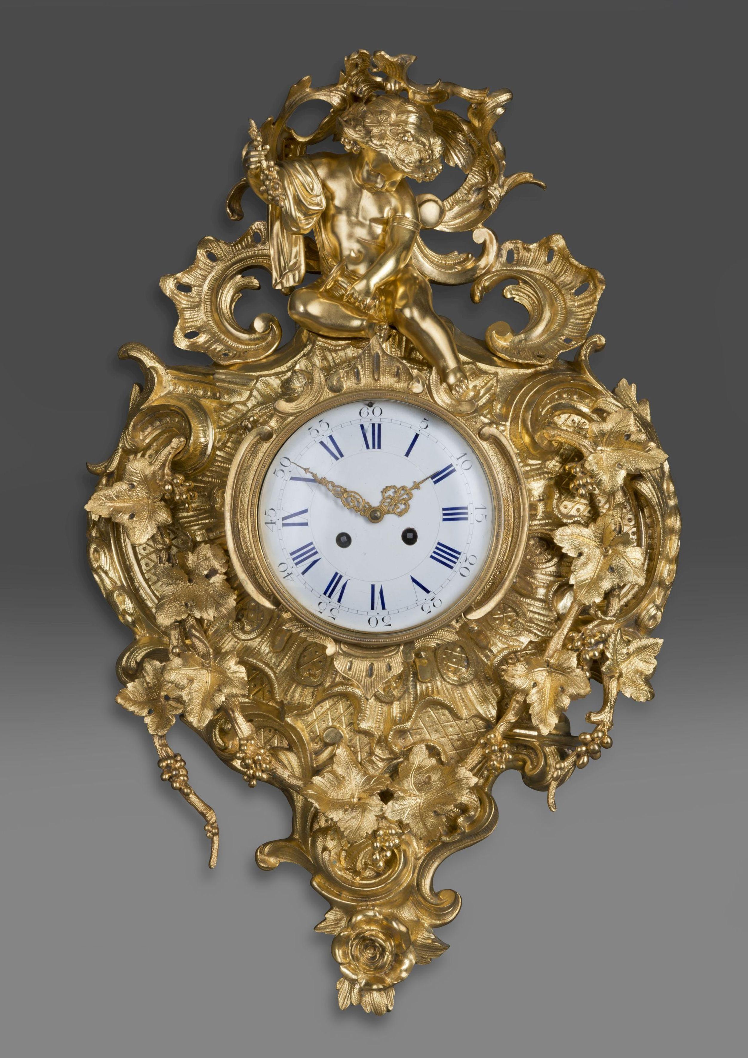 An elaborate Louis XV style gilt-bronze cartel clock.

French, circa 1890. 

Surmounted by a Bacchanalian figure, this elaborately cast cartel clock has a white enamel circular dial with Roman and Arabic numerals and gilt hands. The case cast