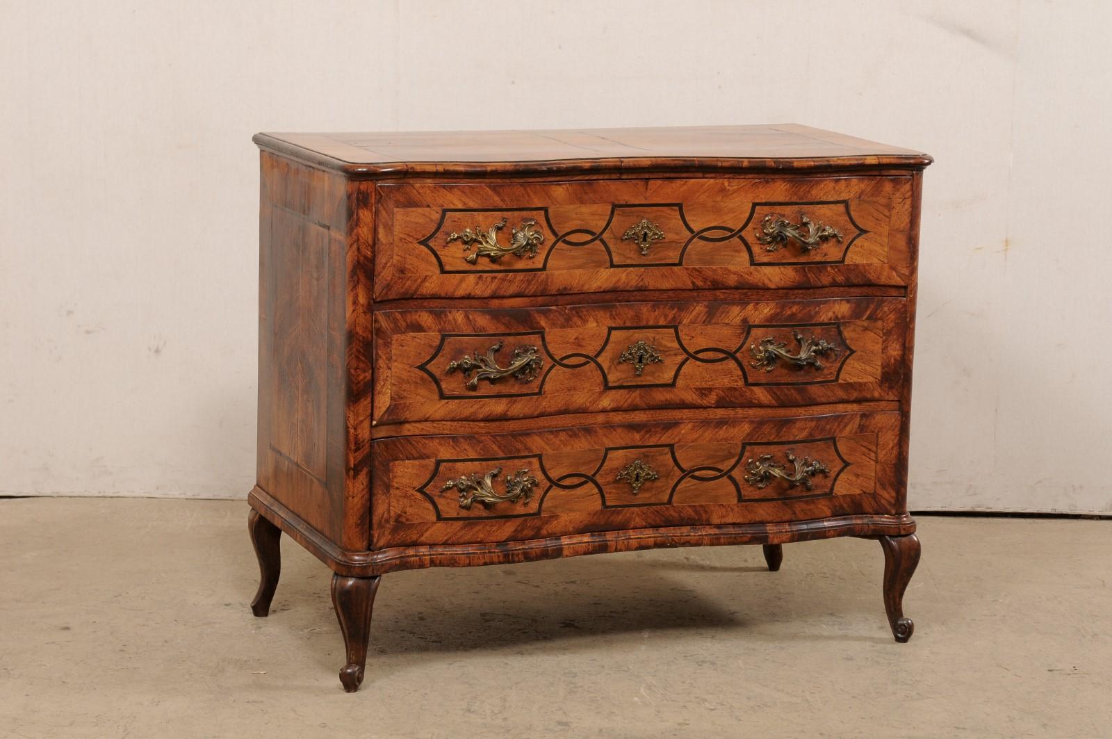 An Italian late Rococo style chest of drawers with serpentine form and book-match veneers, circa 1780. This 18th century chest from Italy features a shapely serpentine top and body, adorn in book-match veneers and inlay throughout, and presently on