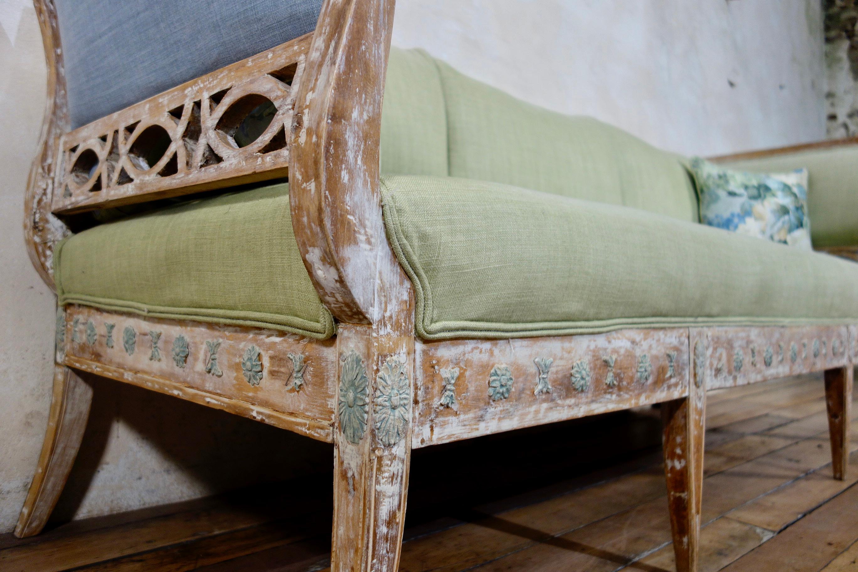 An elegant Swedish 18th century Gustavian sofa from Lindome, circa 1790. Displaying dry-scraped paint to reveal the original paint with green accents to the carved rosettes. Upholstered in green linen, finished with double piped detail.
Raised on