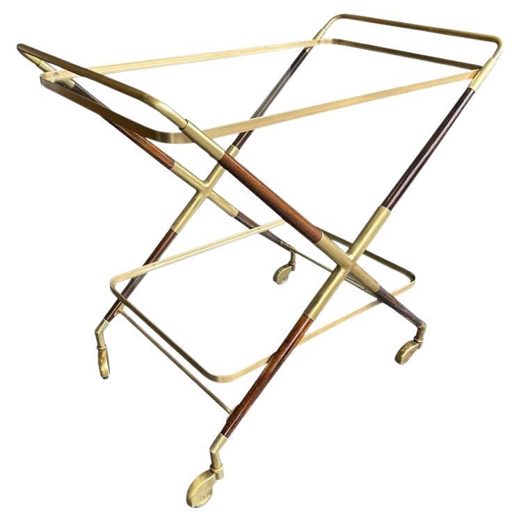 An elegant 1950s Italian lacquered wood and brass bar trolley by Cesare Lacca with two glass shelves and orignal brass castors.
