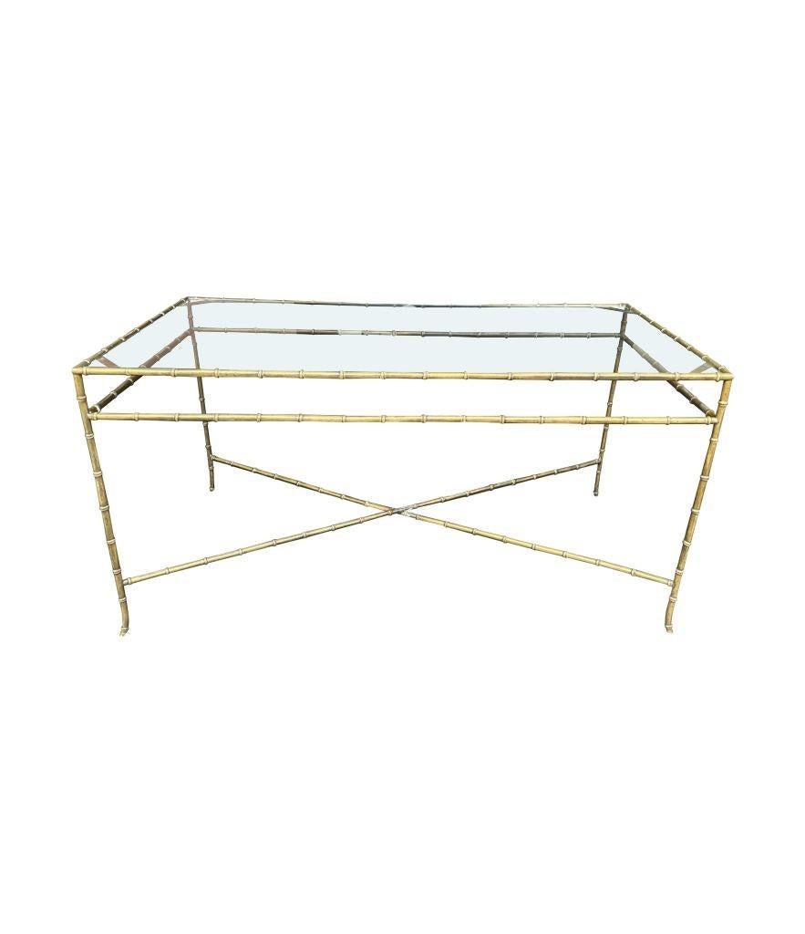 An elegant 1960s Maison Bagues faux bamboo brass coffee table with cross stretcher base and glass top.