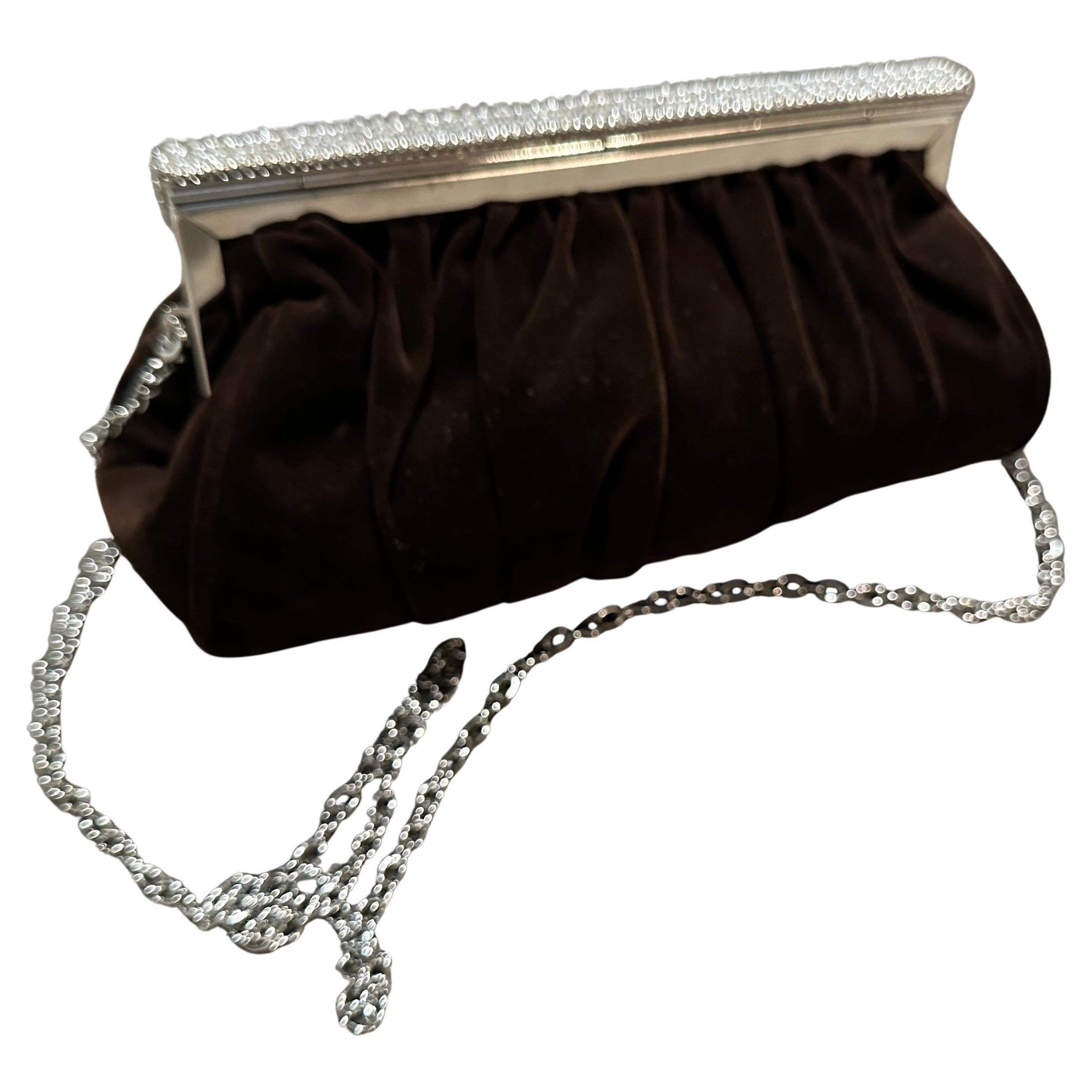 Una squisita borsa da sera italiana vintage degli anni '80. 
Realizzata in Italia con un lussuoso e morbido camoscio marrone, questa pochette è pensata per essere il pezzo forte di ogni outfit. La caratteristica più evidente della borsa è