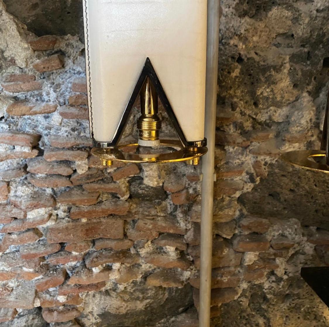 A double light pendant designed and manufactured in Italy in the Eighties. The white and black skin it's in very good condition, the brass it's in original patina.
This double pendant is a stunning lighting fixture that seamlessly combines the