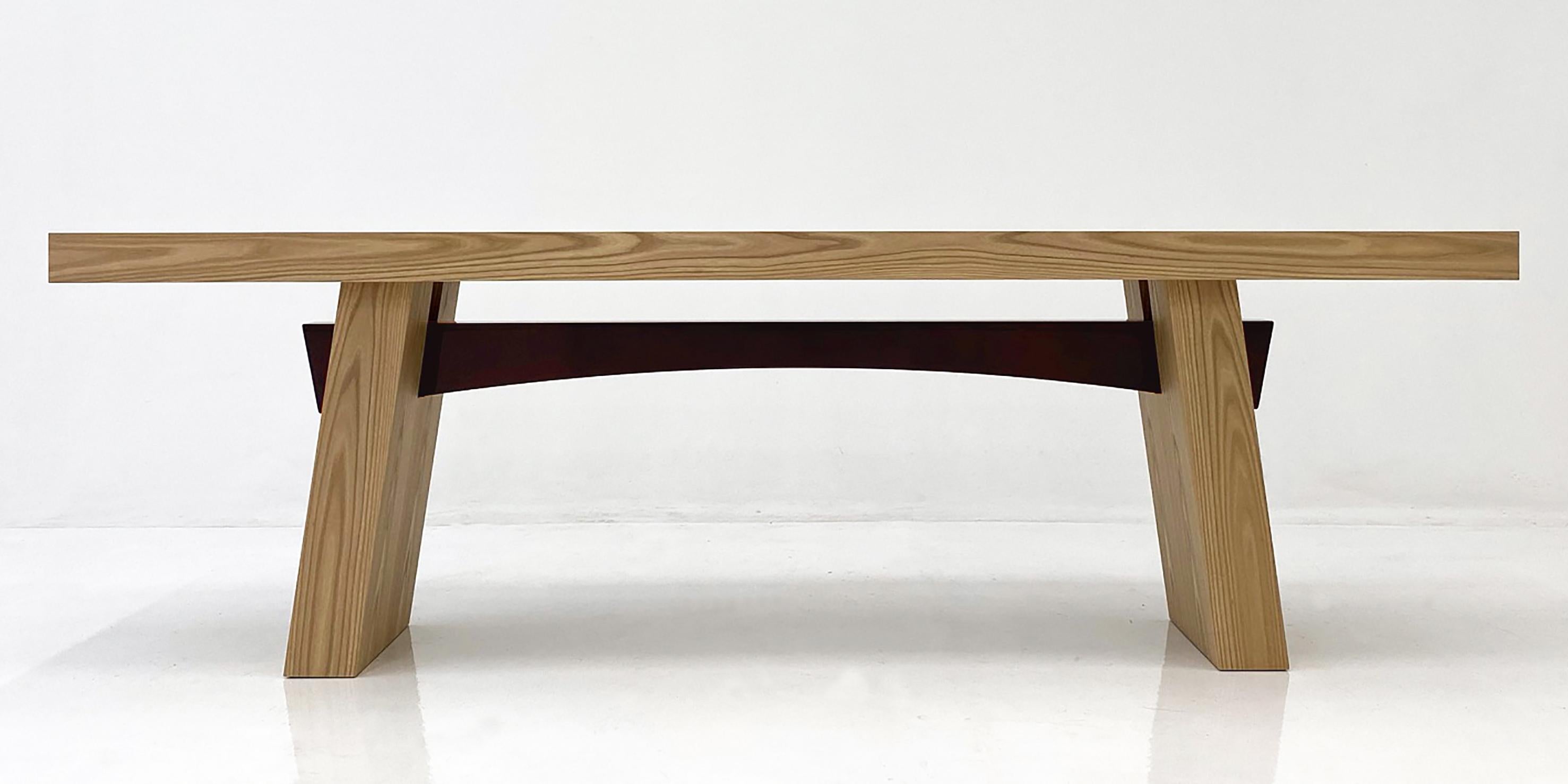 A console of generous proportions with a distinctly thick top and angled legs. Its sleek design is enhanced and enriched by the curve of its contrasting lacquered beam.

Finished in Elm wood, with a dark-red gloss-lacquered beam, the WA console it