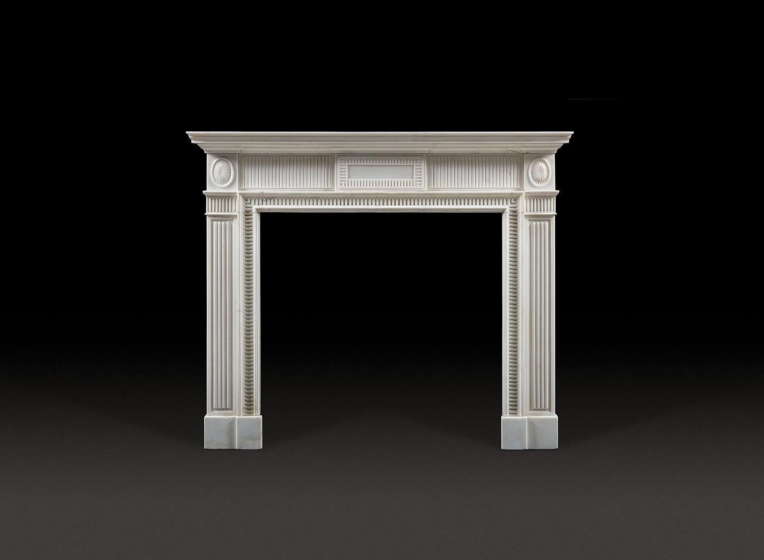 A refined and characterful statuary marble fireplace of strong architectural design, after Sir John Soane. The piece is cleverly decorated with a design of simple open concave finger flutes and stopped, rounded, raised, convex flutes in geometric
