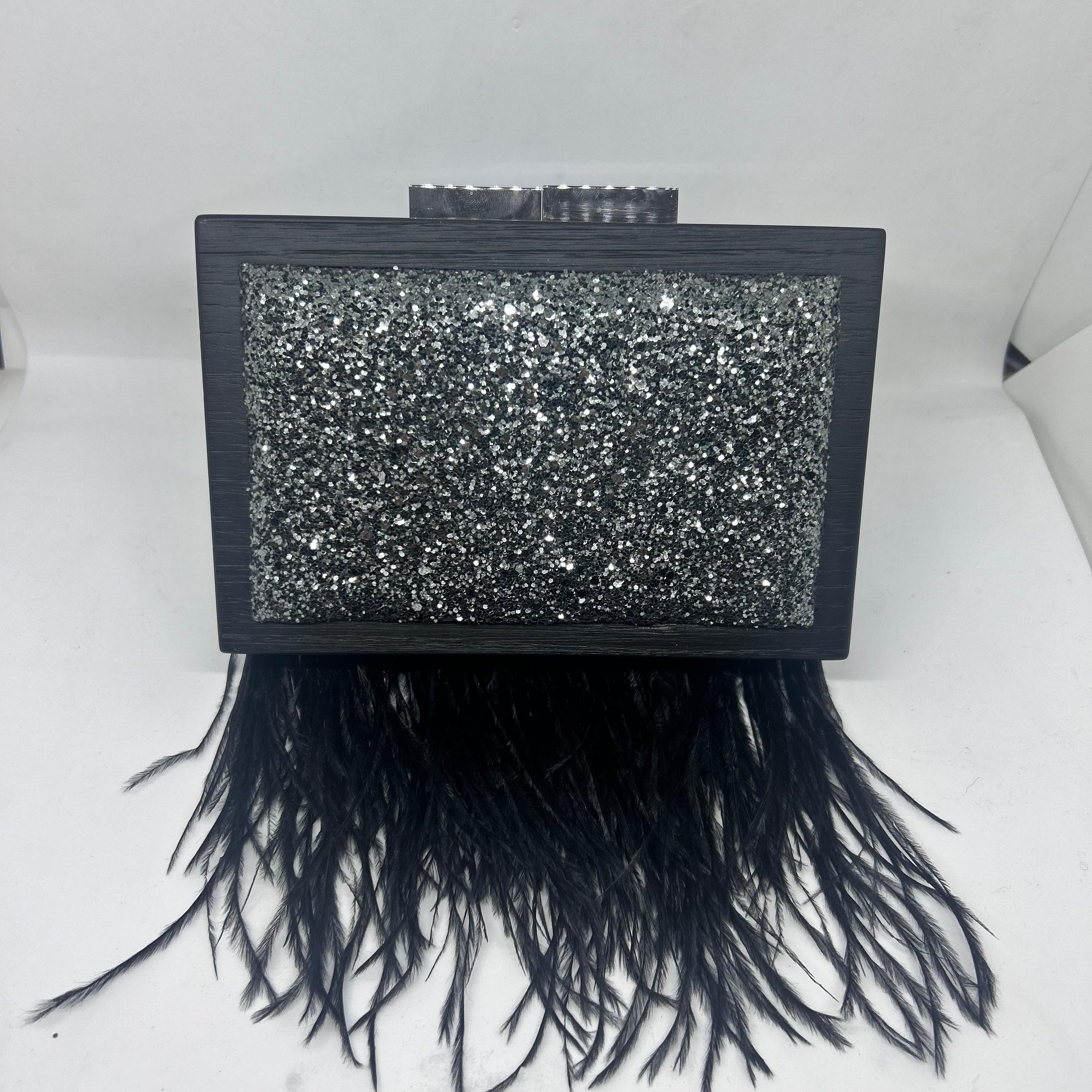 Questa splendida pochette nera sfoggia un design sofisticato e moderno, realizzato a mano da Laurafed, un marchio italiano rinomato per la sua attenzione ai dettagli e alla lavorazione artigianale. Realizzata in legno massiccio di castagno, la