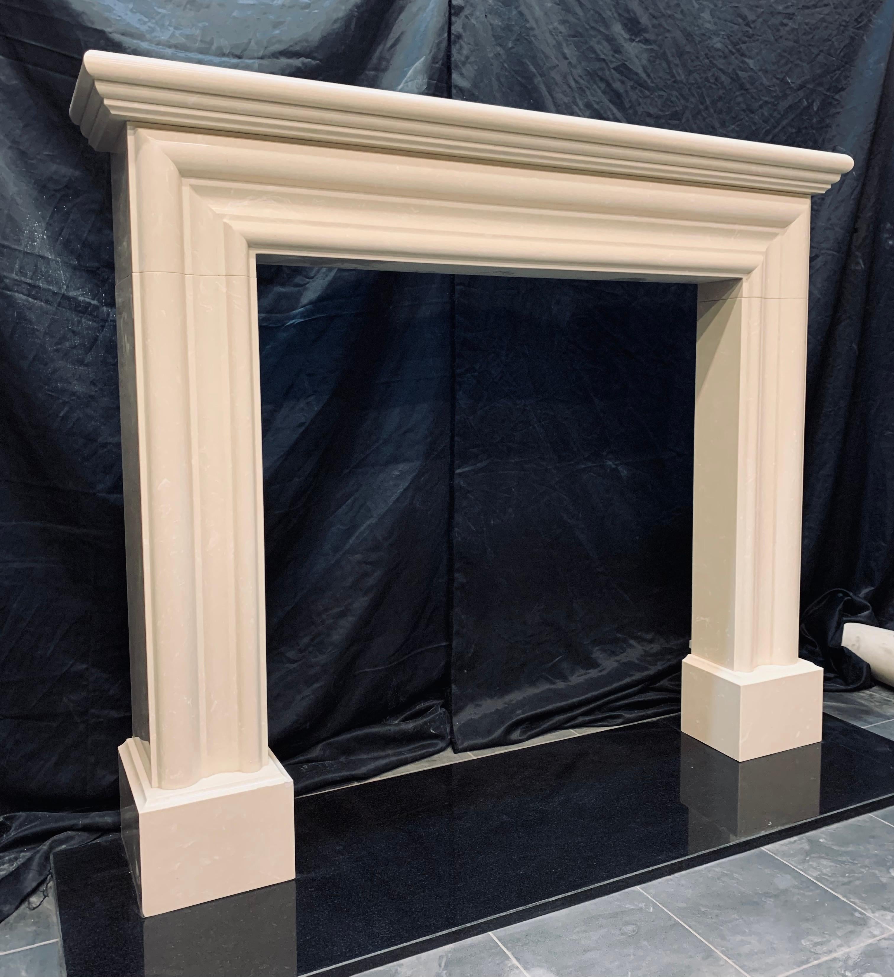 A versatile and elegant bolection fireplace surround in Crema Marfil, a carved bolection frame with side returns and a profiled shelf on top, all resting on moulded foot blocks. 

Crema Marfil marble presents a delectably creamy façade,