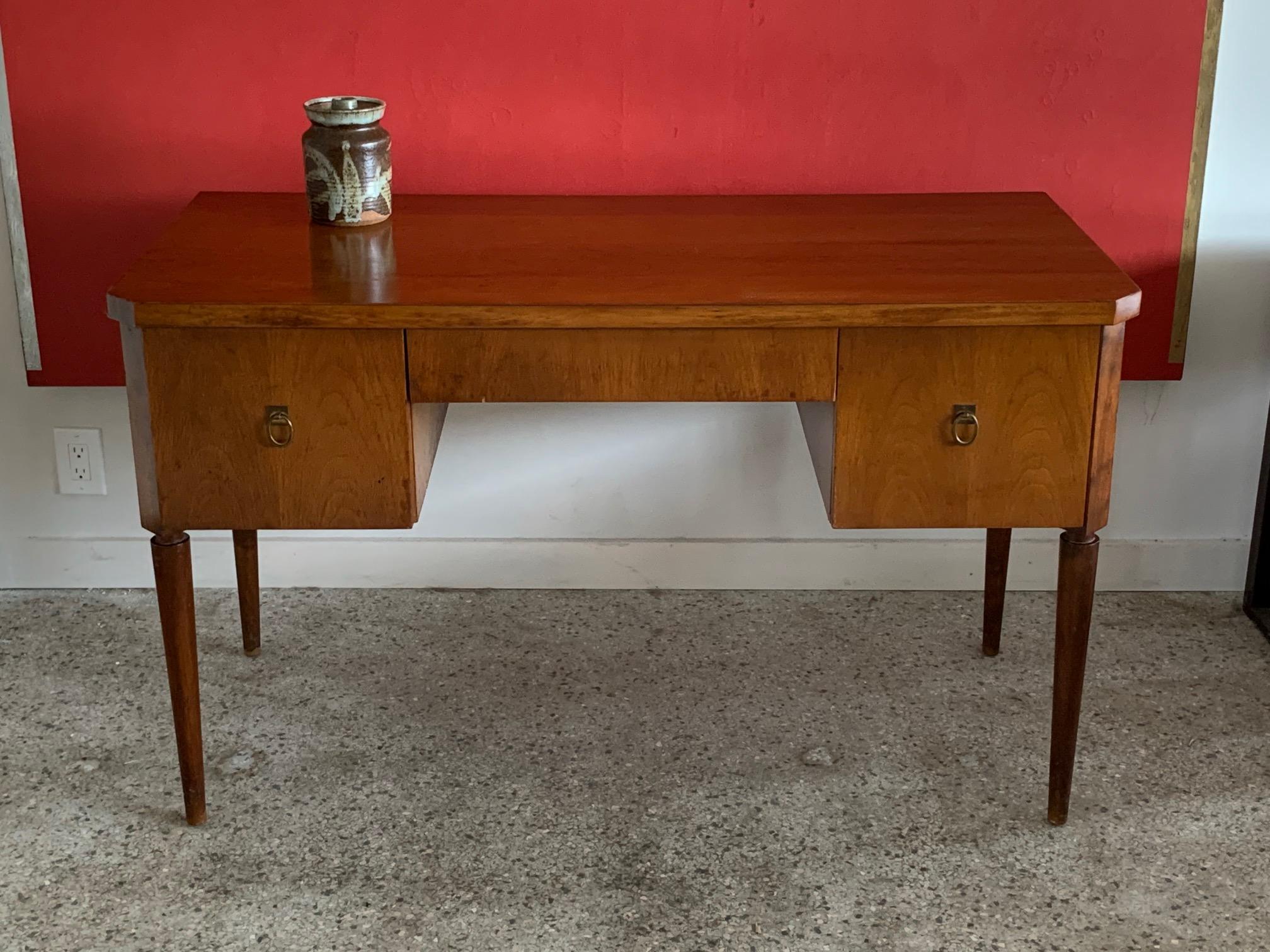 An elegant walnut desk designed by T.H.Robsjohn-Gibbings for Widdicomb, circa 1950s, where he was the lead designer from 1943-1956. T.H. Robsjohn-Gibbings much preferred the visual vocabulary of the classical world, particularly ancient Greek