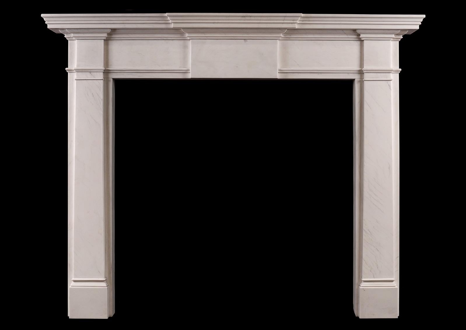 An English Georgian style fireplace. The plain jambs surmounted by scotia moulding and plain end blocks. The frieze with plain centre panel with moulded shelf above. An attractively simple model in the classical style. Modern. N.B. May be subject to