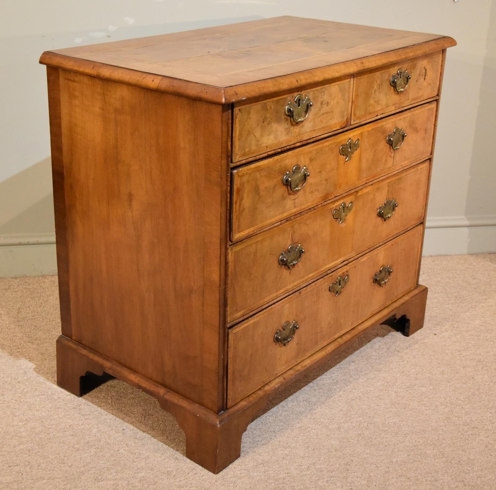 An elegant George I walnut veneered chest of drawers with later feet and handles

height 33.5