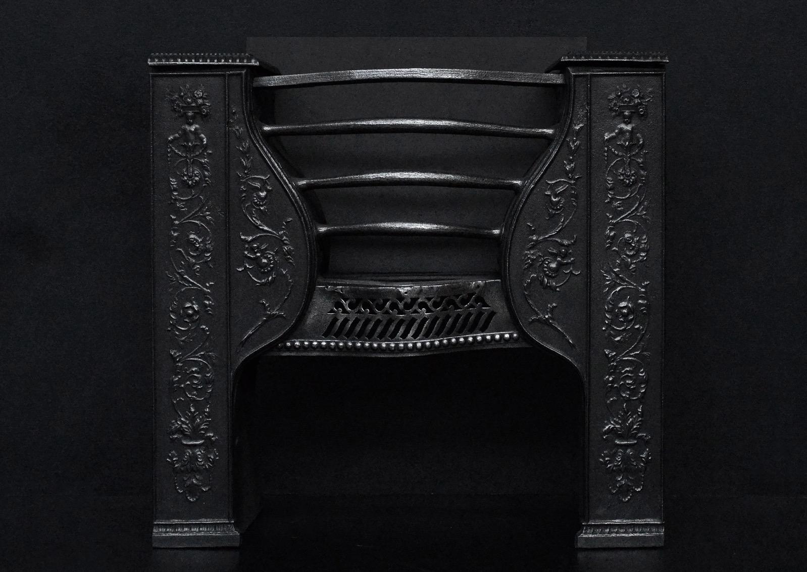 An elegant cast iron hob grate. The decorative front with foliage and scrollwork throughout. The burning area with shaped front bars with pierced fret below. English, 19th century.

Measurements: 
Width at front: 640 mm 25 1/4 in
Width at back: