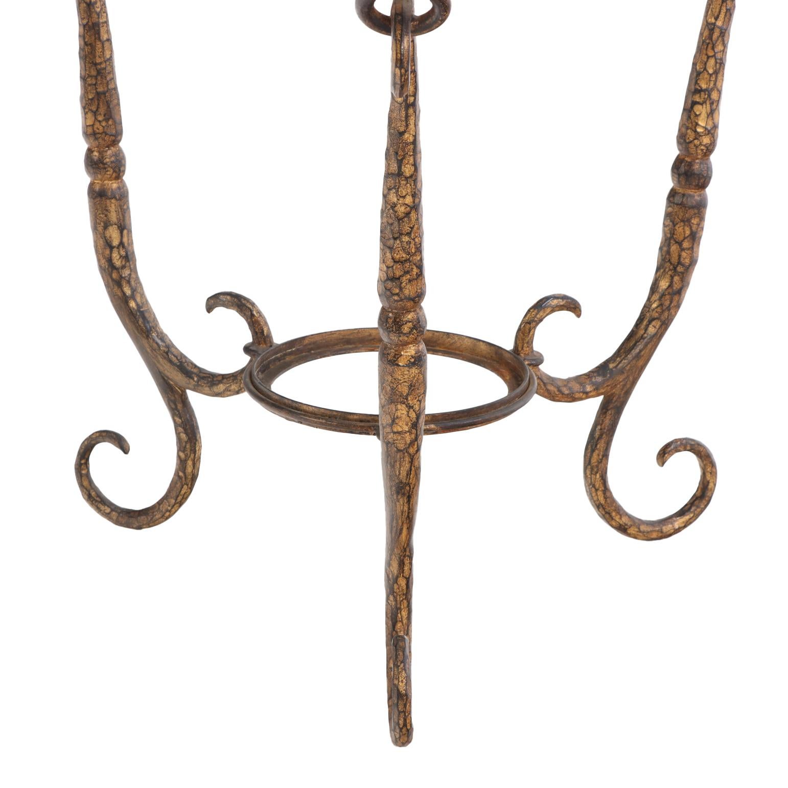 Esta refinada mesa tiene un tablero redondo de cristal sostenido por patas de hierro dorado graciosamente curvadas, unidas por un travesaño circular inferior para mayor estabilidad. Atribuido posiblemente a Giovanni Banci, escultor y diseñador de