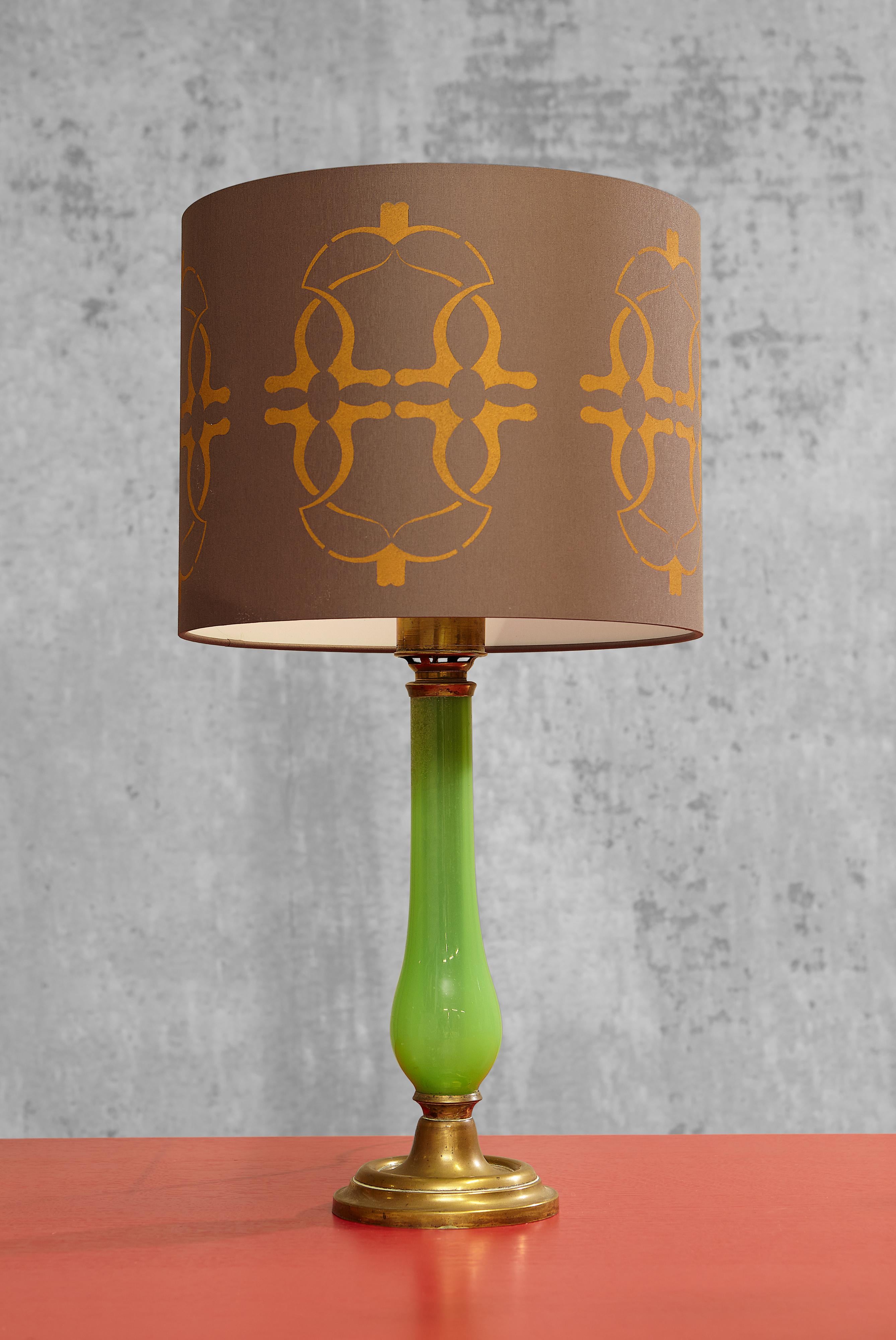 An elegant large green opaline glass table lamp on a round, profiled messing base with a profiled messing rim.

The lampshade by Brinkman Collections can be acquired separately, but is not included in the prize.  
