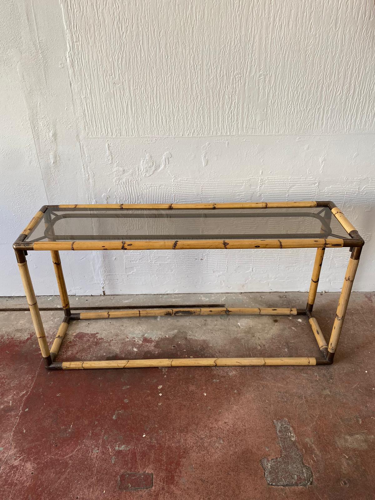 An elegant Italian Mid-Century Modern large bamboo and smoked glass console or sofa table by Giovanni Banci circa 1970. 
The original smoked glass top accompanies the piece, bronzed corners and connections with aged apperance. The natural bamboo has