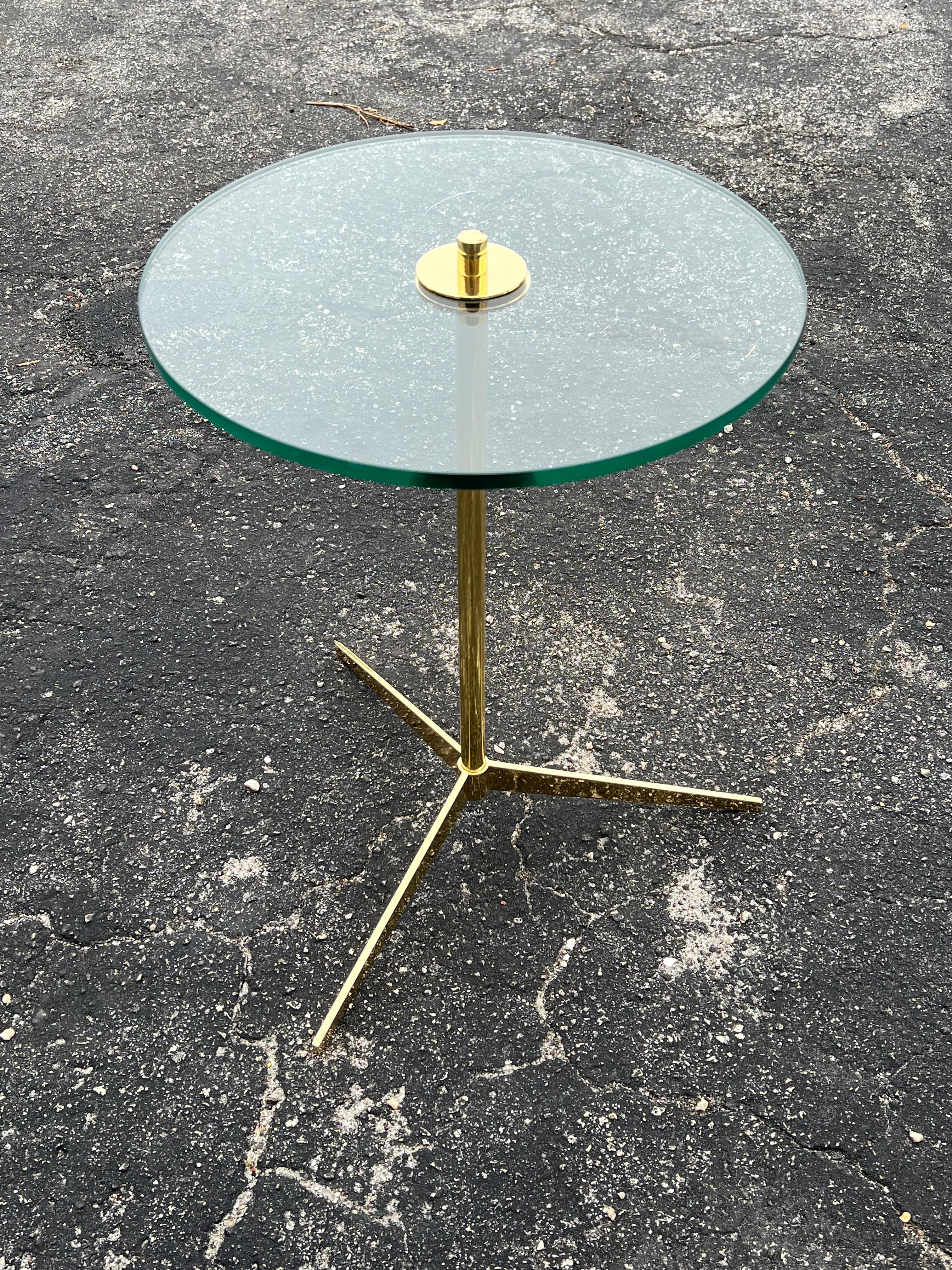 An elegant gueridon or tripod table in polished, lacquered brass and glass top. Perfect as a drink stand, side table, etc...Classic mid century look.