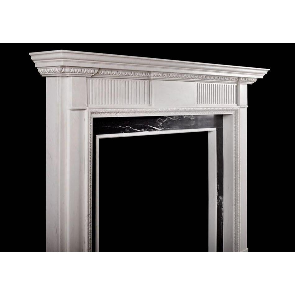 An elegant neoclassical style limestone fireplace, reflecting the designs of the late 18th century. The fluted frieze with plain centre and side blockings. The inner moulding of carved waterleaf, and the moulded shelf with egg and dart bed moulding.