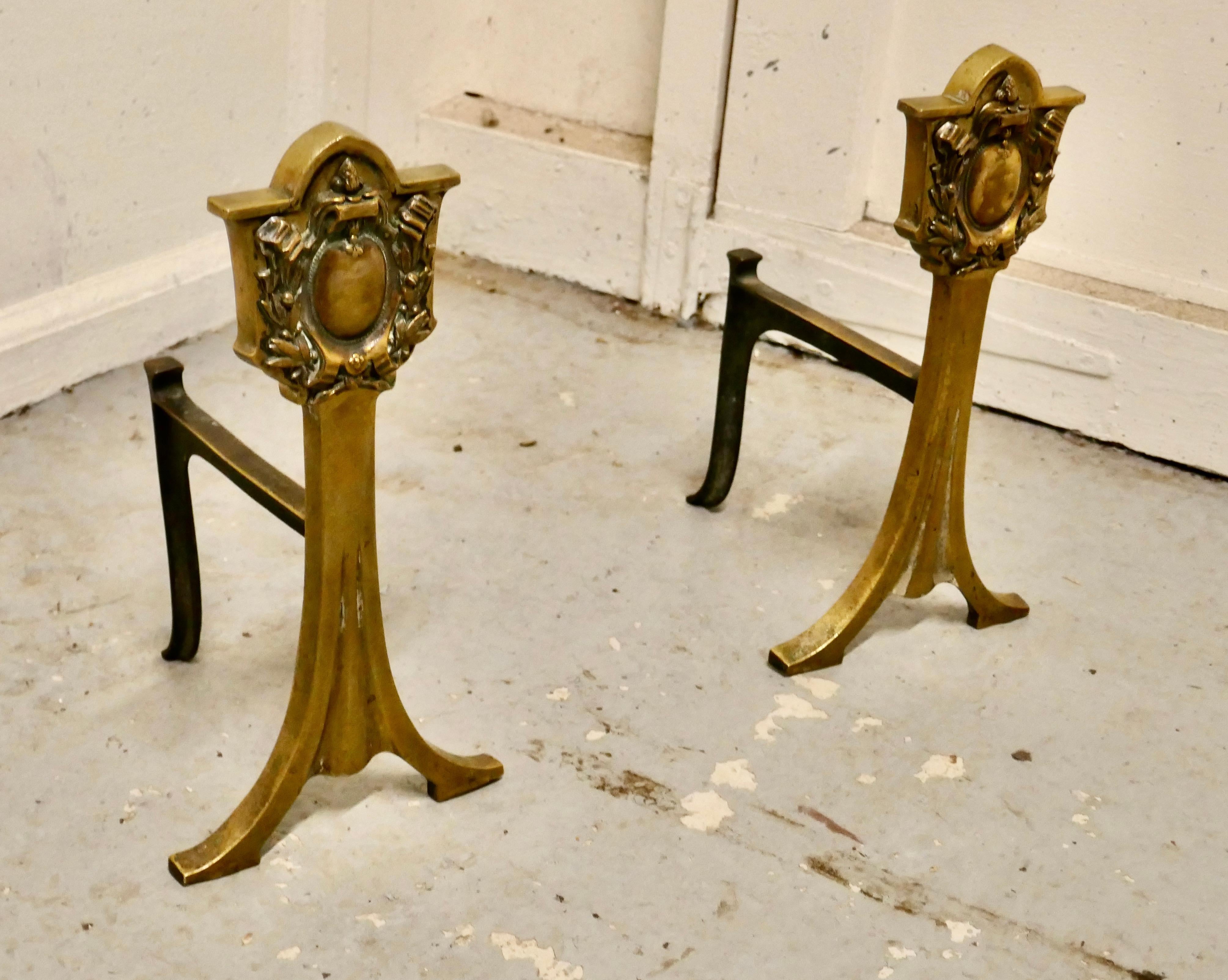 An elegant pair of 19th century brass andirons or fire dogs

This very attractive pair of brass andirons, they they are Regency in style with a classical shield on the top and splayed feet

The andirons are 12” high, 7” long and 7” wide across