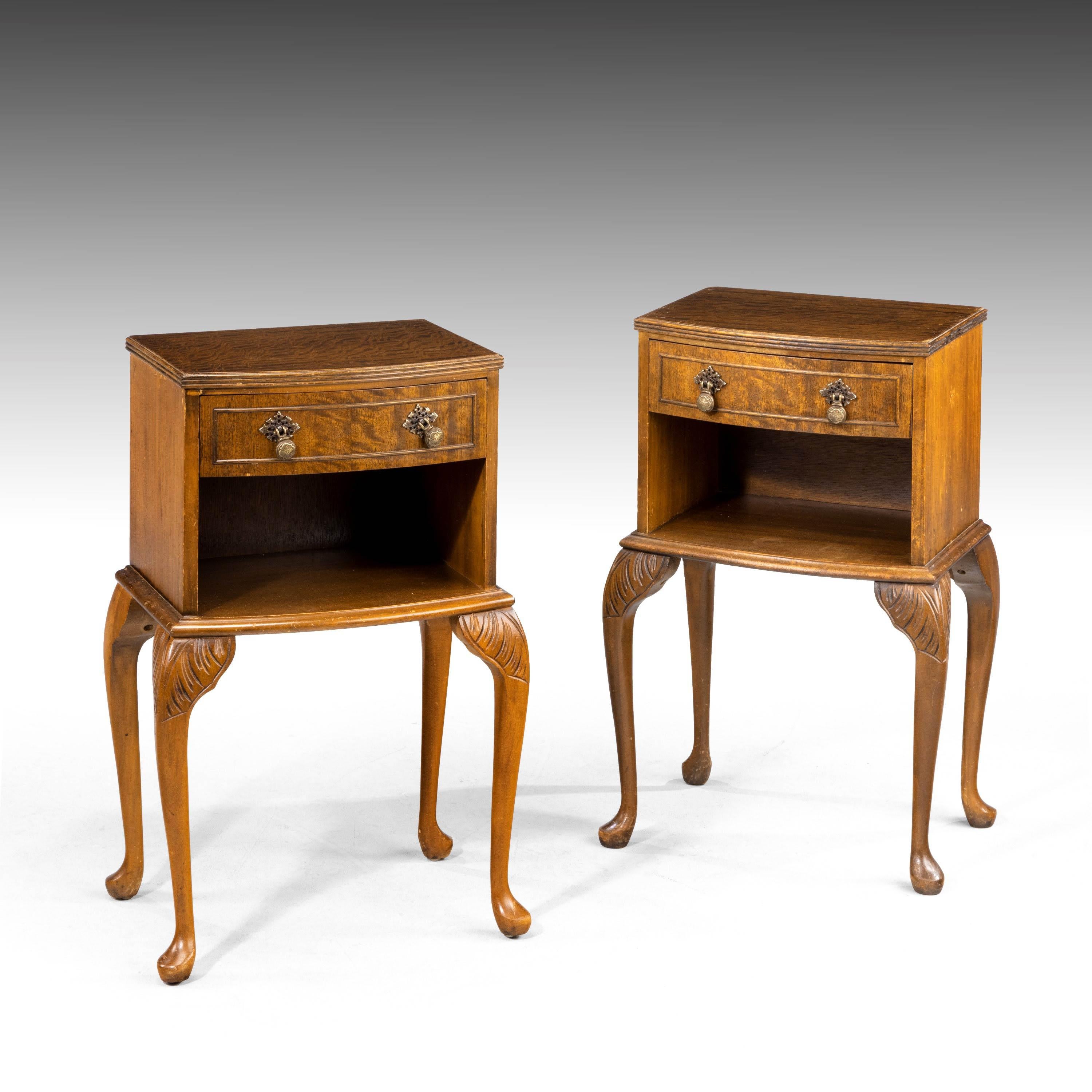 A elegant pair of highly figured mahogany bedside cabinets of bow front section. On well carved cabriole supports. Open sections to the centre below drawers.
 