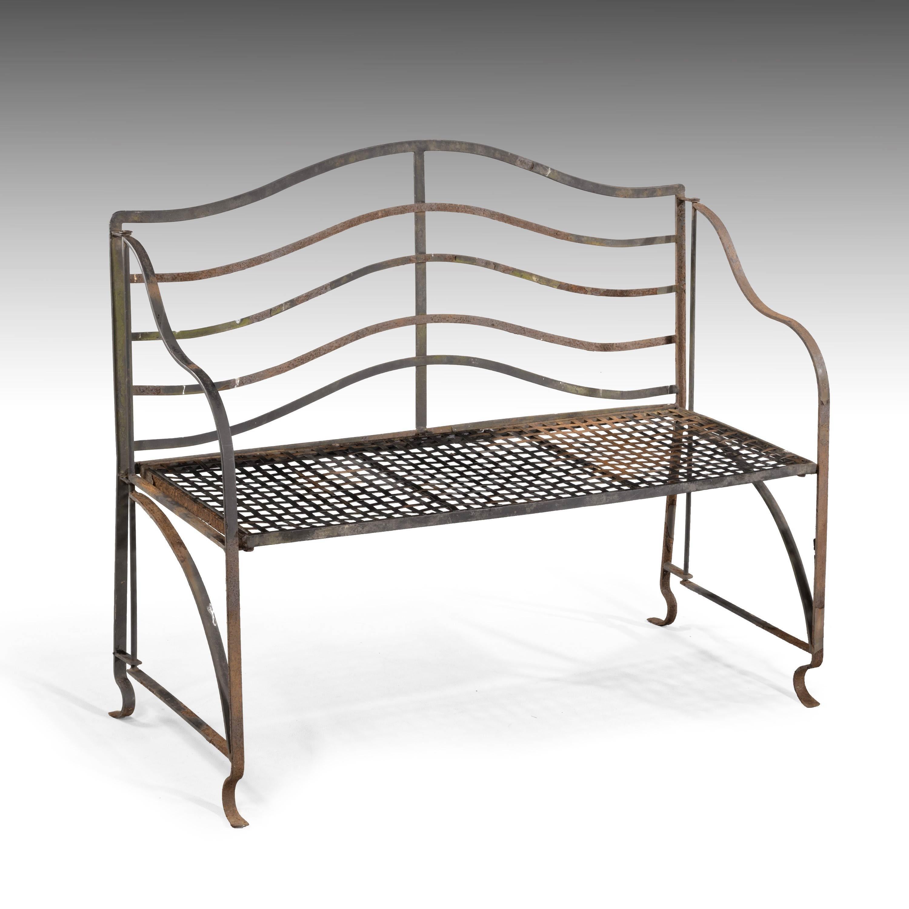 A most elegant pair of iron garden benches of particularly fine line. With the original strapwork woven iron seats.
Measures: Seat height 17.25