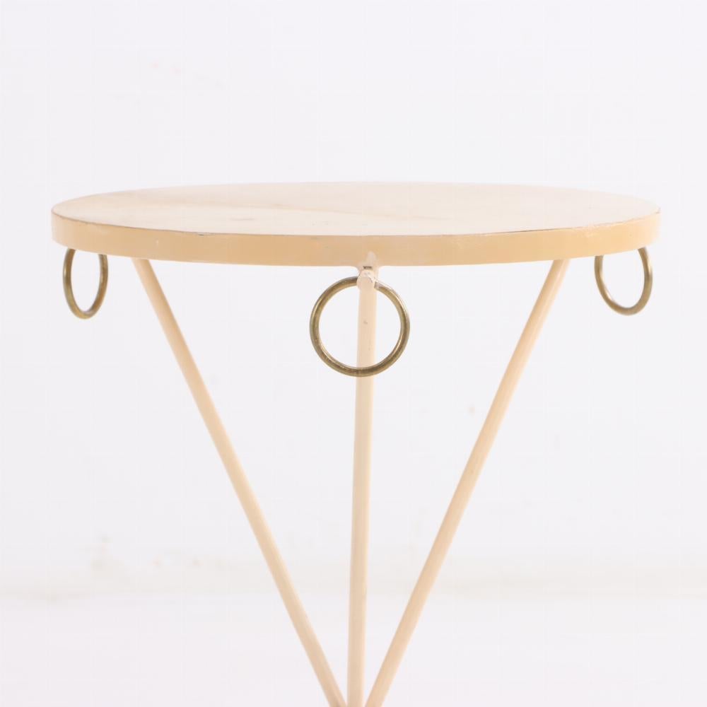 An elegant pair of painted iron drinks tables in the manner of Jean-Michel Frank. Contemporary. The tables having parchment covered tops and brass ring decorated aprons supported by an iron tripartite bases. 