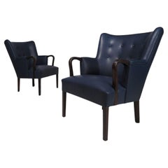 Une élégante paire de fauteuils en bois de rose et cuir de Kaare Klint