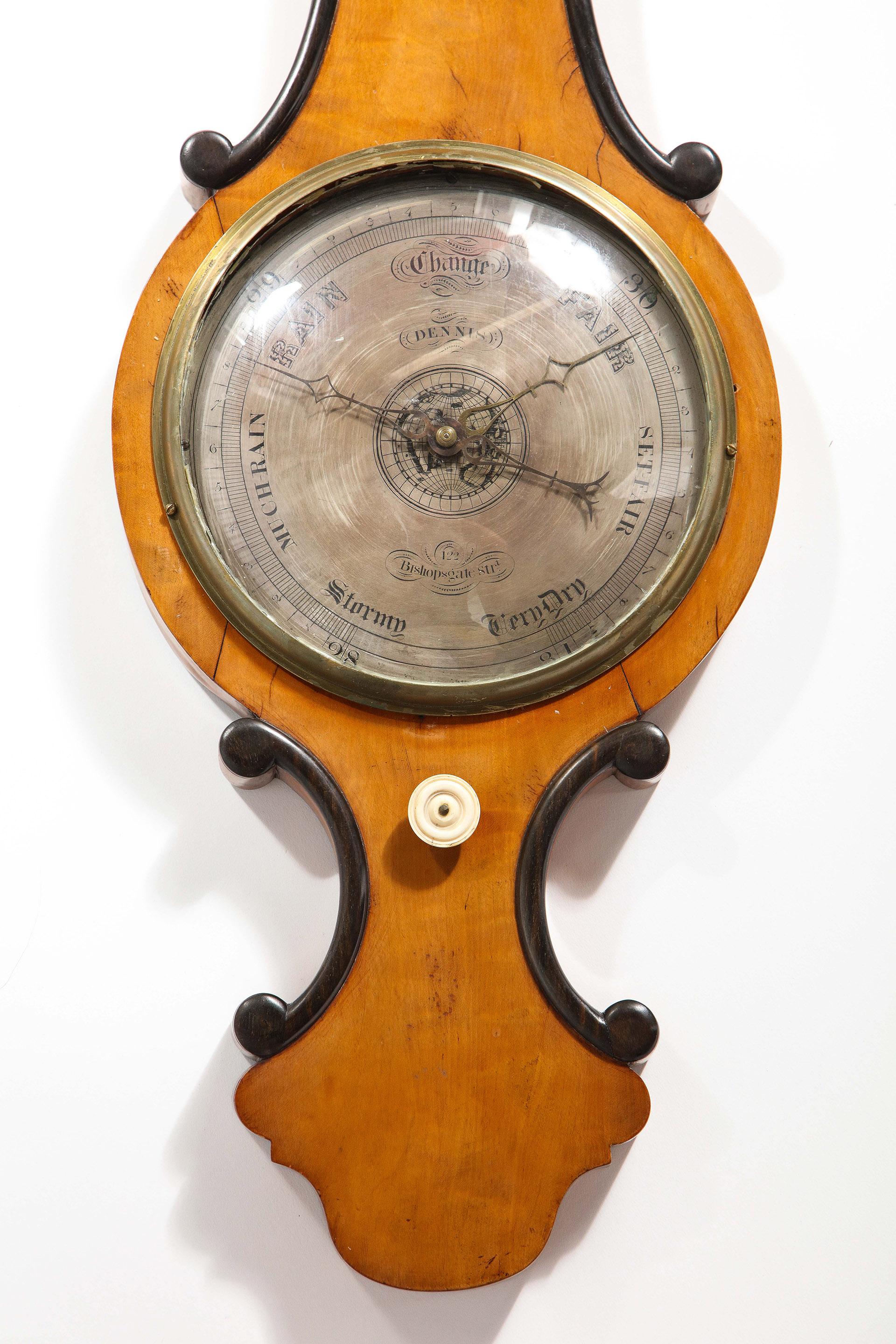 The banjo form barometer in satinwood with an ebony scroll outline, showing a brass-mounted thermometer over a similar style barometer. The back opening to reveal the original blown glass elements.