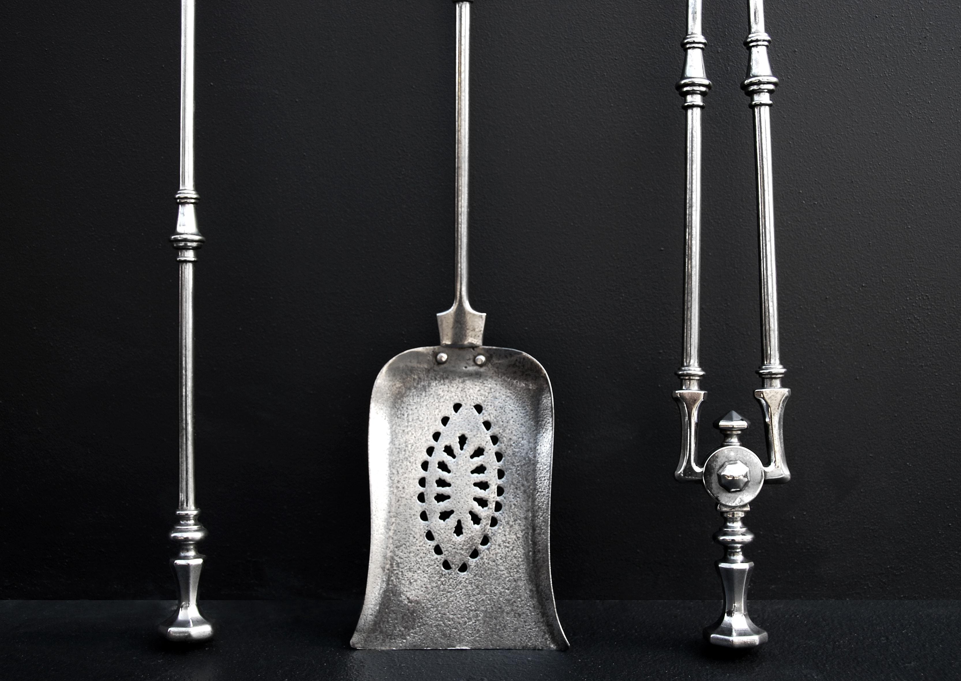 An elegant set of 19th century English steel firetools. The faceted octagonal handles with turned motif to shafts. Pierced shovel.

Length:	760 mm      	29 ⅞