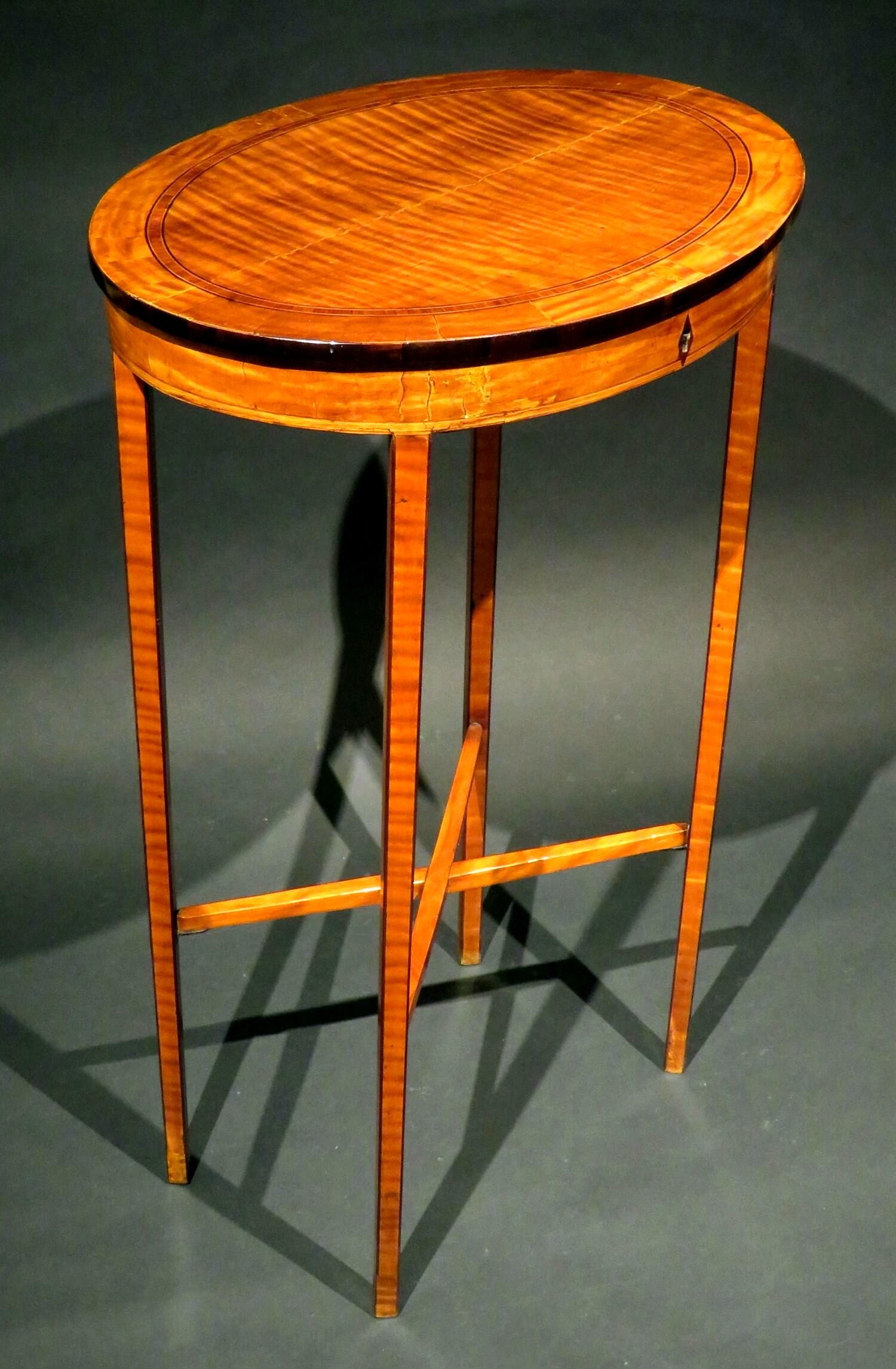 Une table de travail / table d'appoint en bois de satin très élégante et remarquable, présentant un plateau ovale richement figuré 