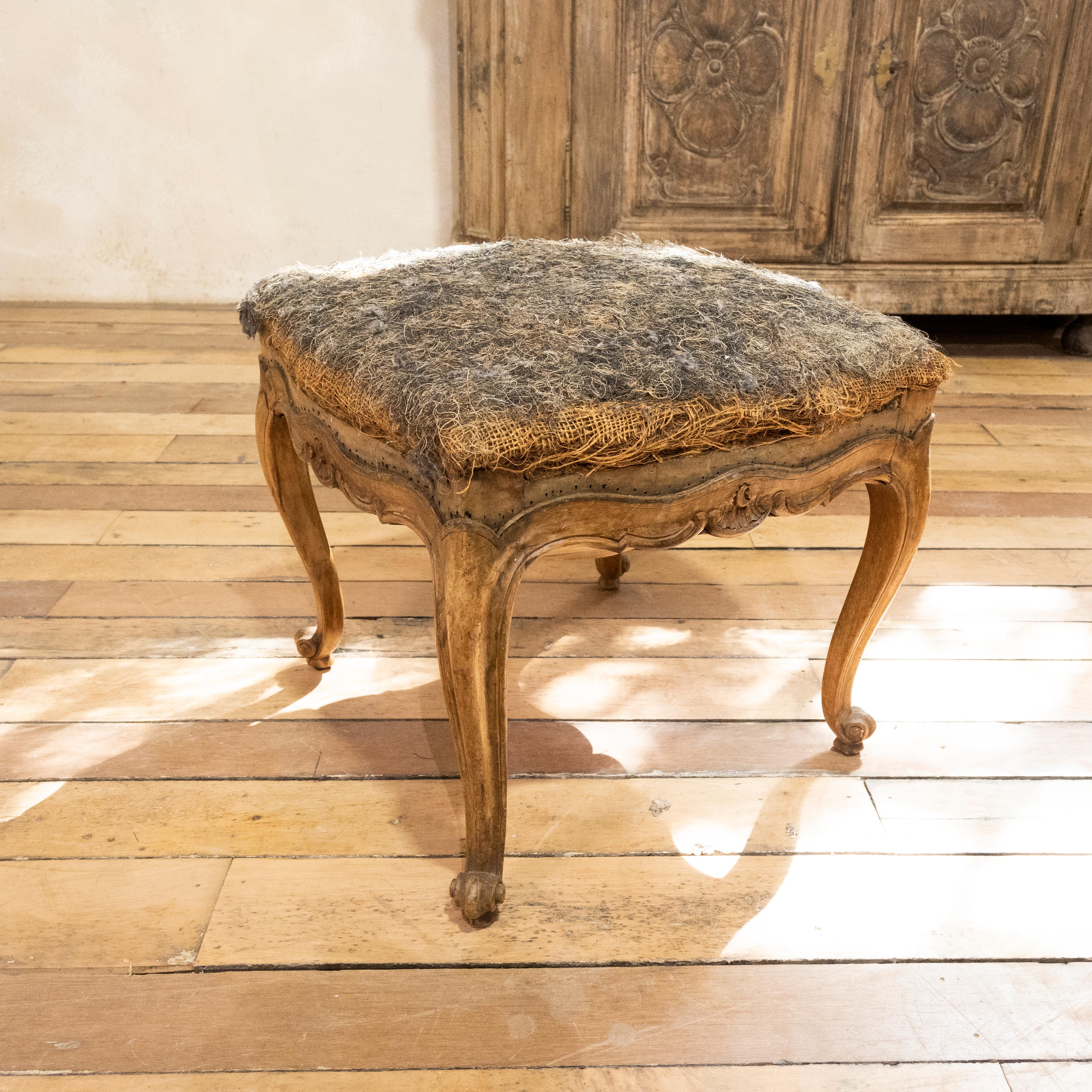 An elegant Louis XV stool carved in Lyon, France. Raised on four cabriole legs and acanthus leaf decor on the shoulders, with a floral carved motif to the scalloped apron.
Demonstrating a rich walnut patina to the frame, ready for reupholstery.
