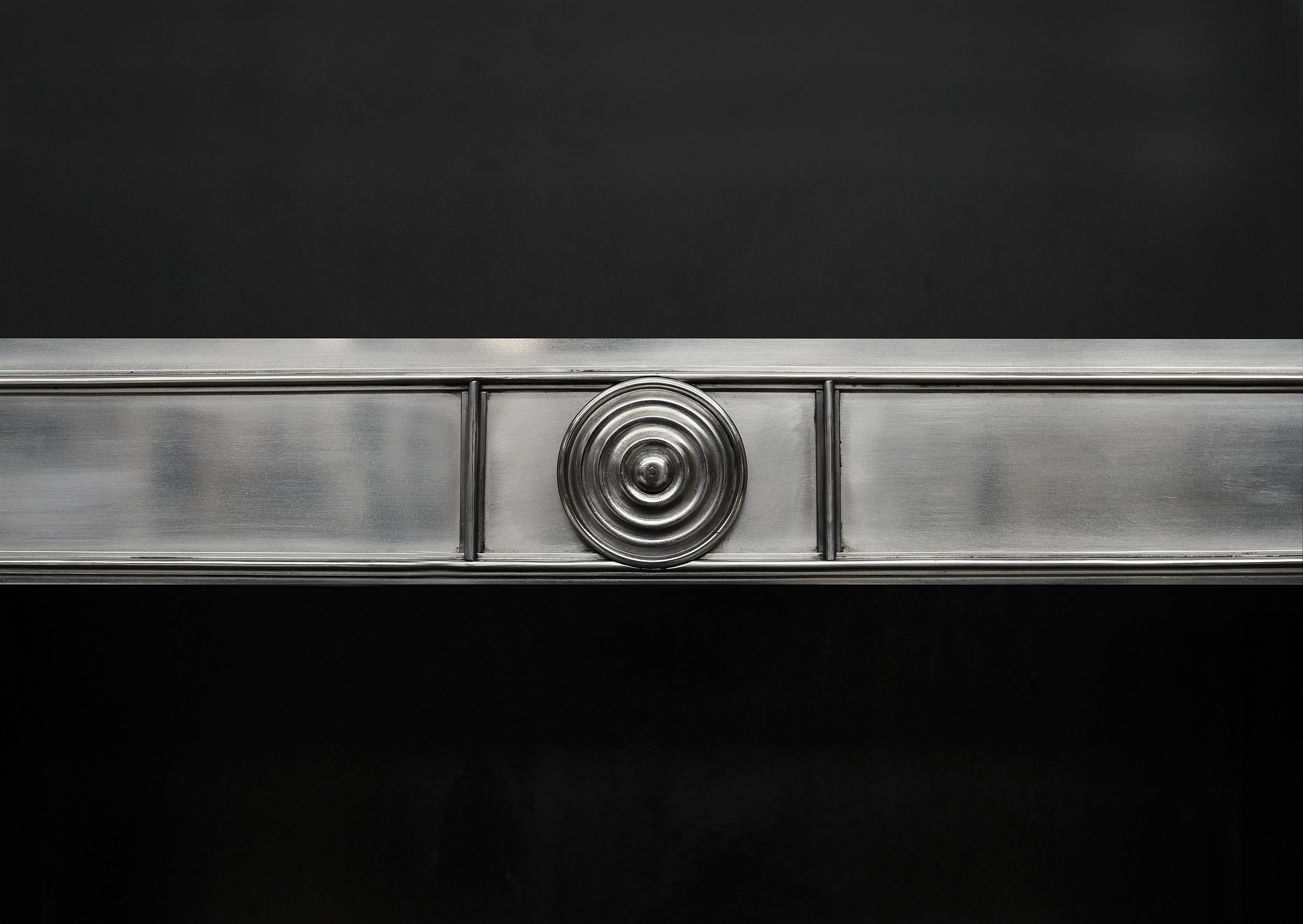 An elegant steel register grate in the Georgian style. The frame with mouldings to edges and circular steel patera to top. The burning area with steel bars and panelled front hobs. English, modern. NB. May be subject to an extended lead