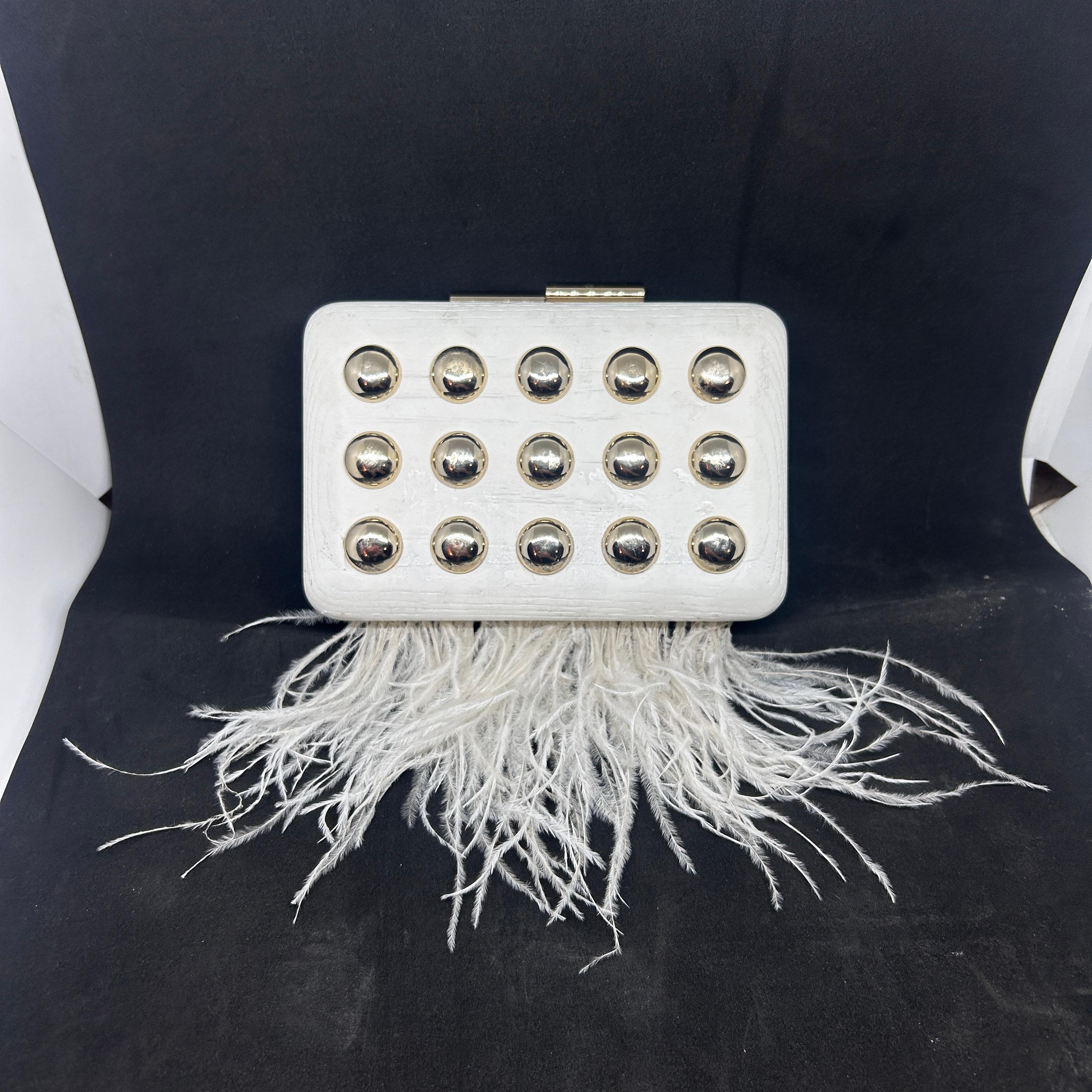 Questa borsa da sera realizzata da Laurafed è un'eccezionale fusione di materiali, texture e intricata lavorazione artigianale.
Il corpo della borsa è realizzato in legno massiccio di castagno, accuratamente selezionato per la sua durata e le sue