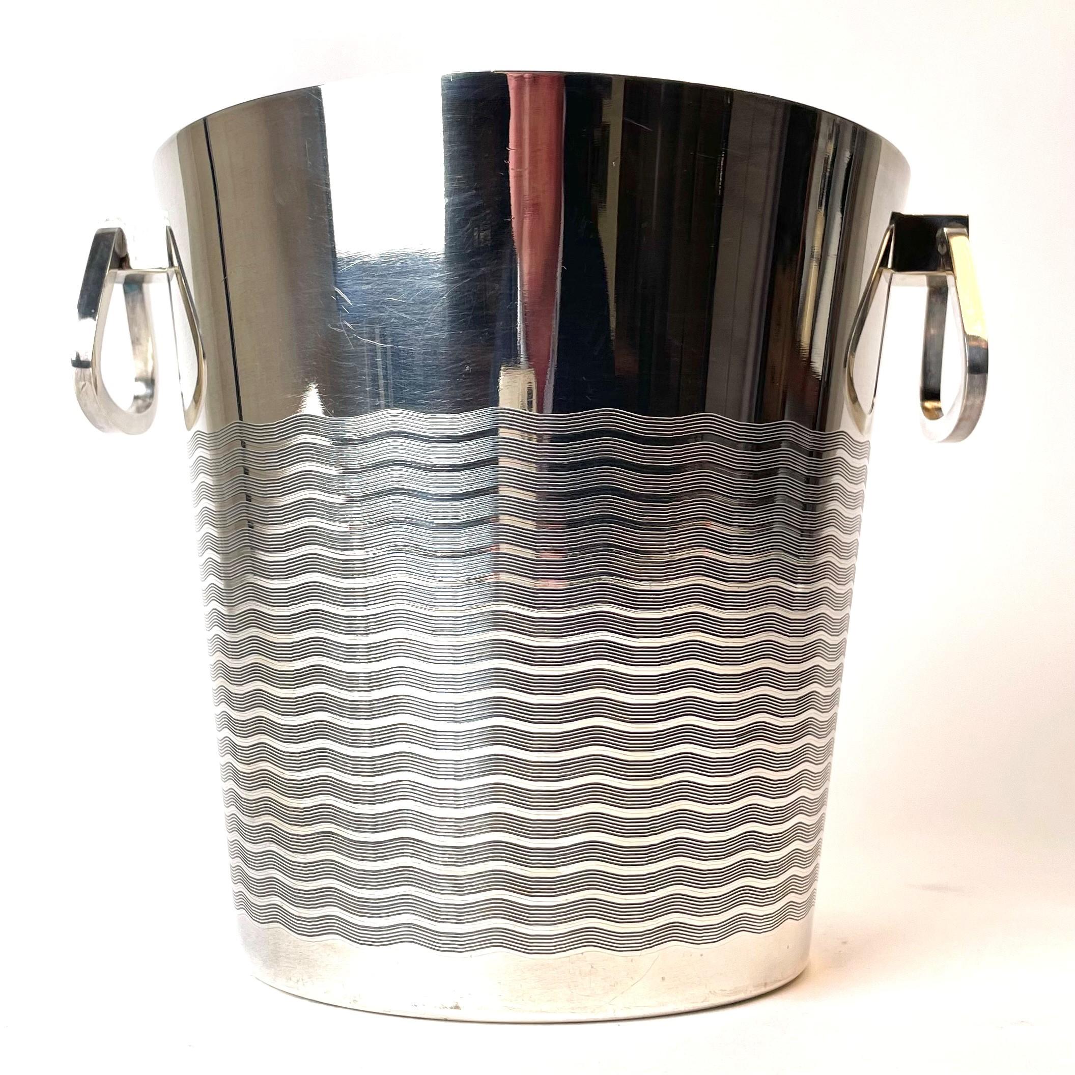 An elegant wine cooler with decor of waves from 1930s - 1940s. Made in silver plated brass in France.

The wine cooler is in good condition but has a little wear at the bottom (see picture) where the brass is visible.

Wear consistent with age