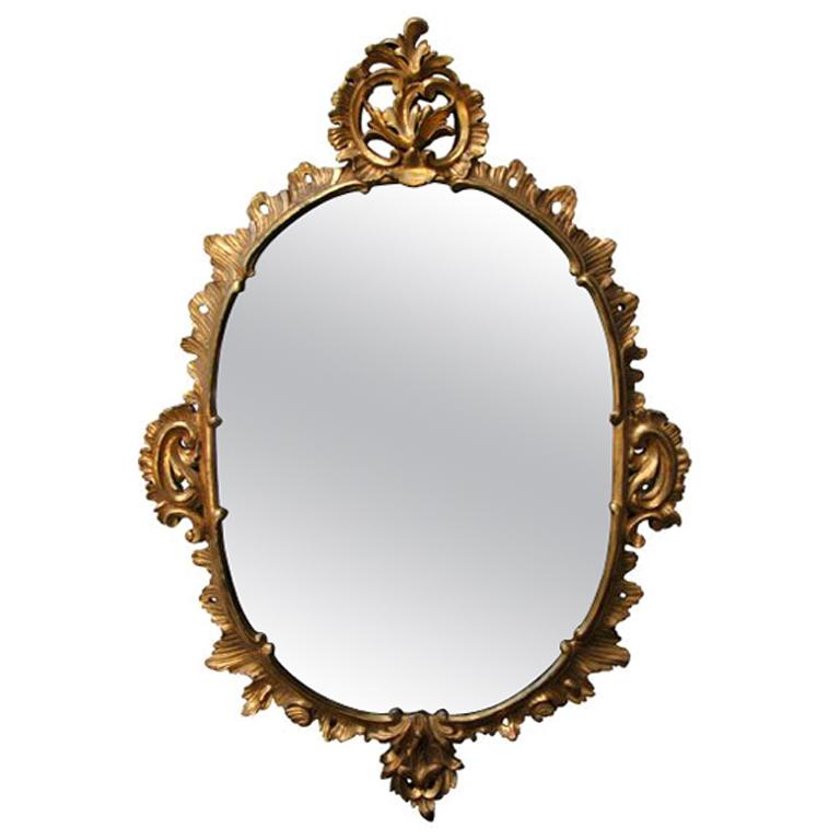 An Elegantly Carved French Louis XV Style Rococo Giltwood Oval Mirror For Sale