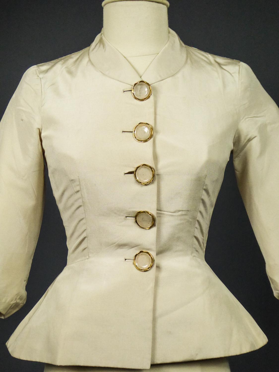 Circa 1947-1950
France Haute Couture

Bar set jacket in ivory silk Ottoman by Elsa Schiapparelli dating from the late 1950s. Jacket replica of the New-Look Bar set by Christian Dior 1947 but with the humor and distance that characterizes the work of