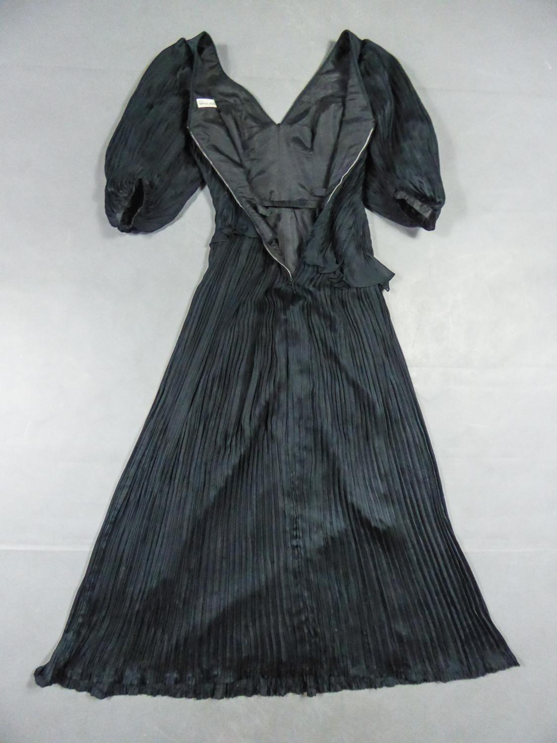 Circa 1985-1990
Paris Haute Couture

Beautiful long evening dress in black silk crepe by Emanuel Ungaro Haute Couture numbered 295-5-85 around 1985/1990. Superb contrast of the work of pleats between the asymmetry of the bodice hugging the hips and