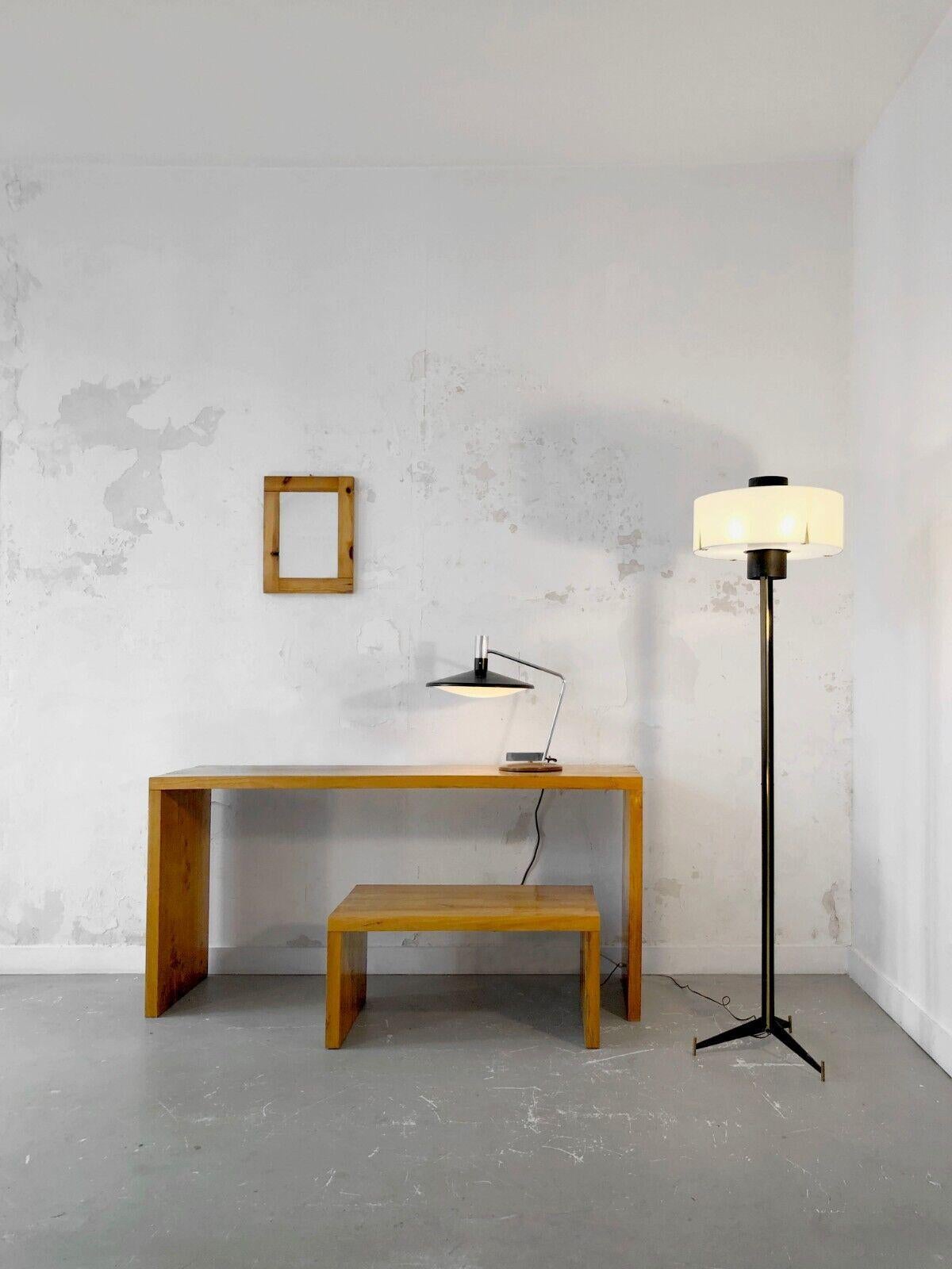 An exceptionnel tripod floor lamp, Modernist, Fifties, Bauhaus, with a tripod base in black lacquered metal on 3 cylindric feet in golden patina brass; the vertical axis in three pieces in black lacquered metal with a golden brass line, crowned with