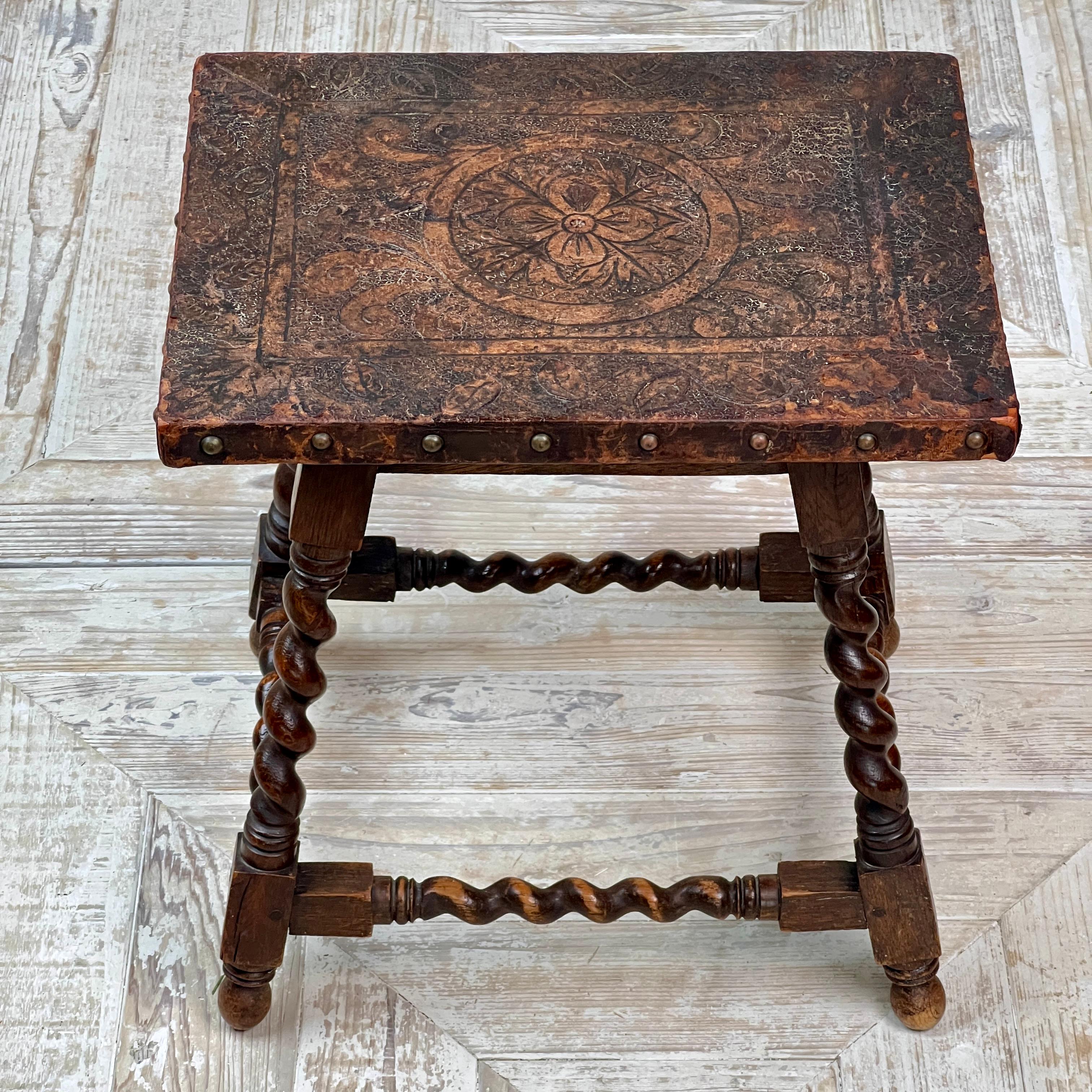 Un grazioso tavolino o tavolo occasionale in Oak e pelle goffrata, di dimensioni ridotte, risalente ai primi anni del 1900.

La parte superiore in pelle goffrata è caratterizzata da dettagli floreali e rifinita con borchie decorative.

Il pezzo