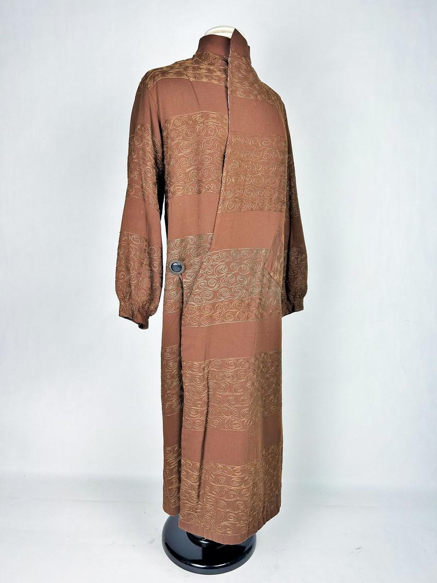 Alrededor de 1920
Francia
Precioso abrigo de invierno de un diseñador desconocido en crepé de lana color chocolate, bordado con la técnica Cornely y datado de principios del periodo Art Déco en Francia. Corte tubular, largo y holgado, con cierre de