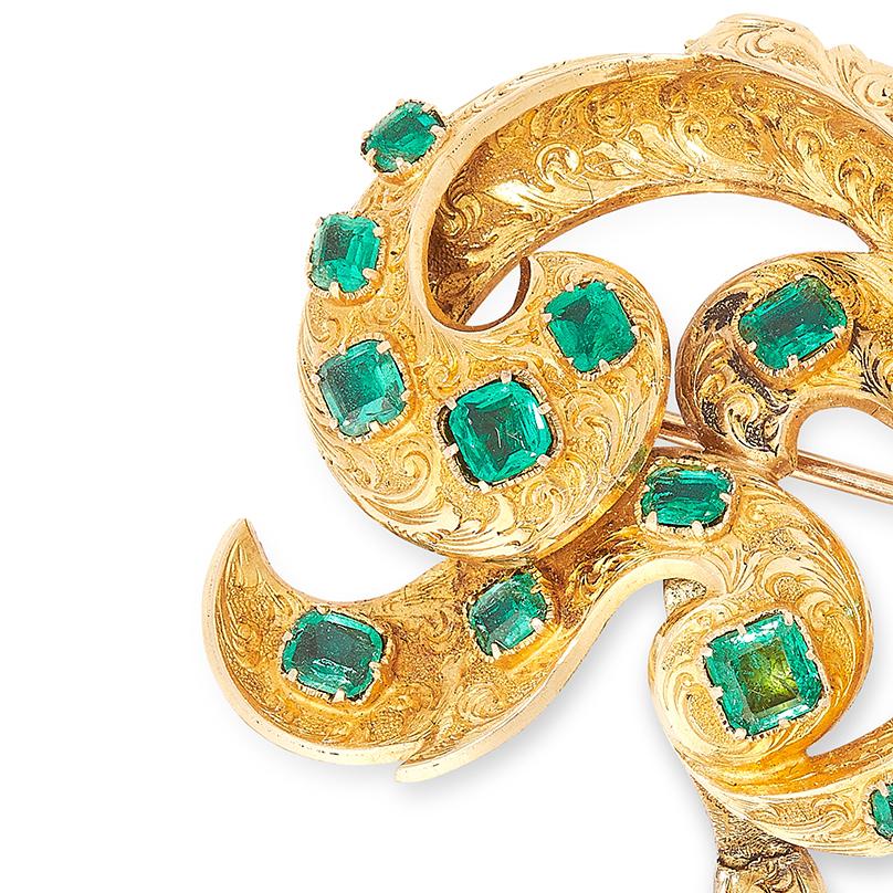 A 19th century emerald brooch, of foliate scroll design, the articulated body decorated in engraved foliate decoration and set with emerald cut emeralds, unmarked.

Length: 7.2cm
Gross weight: 12.2g
